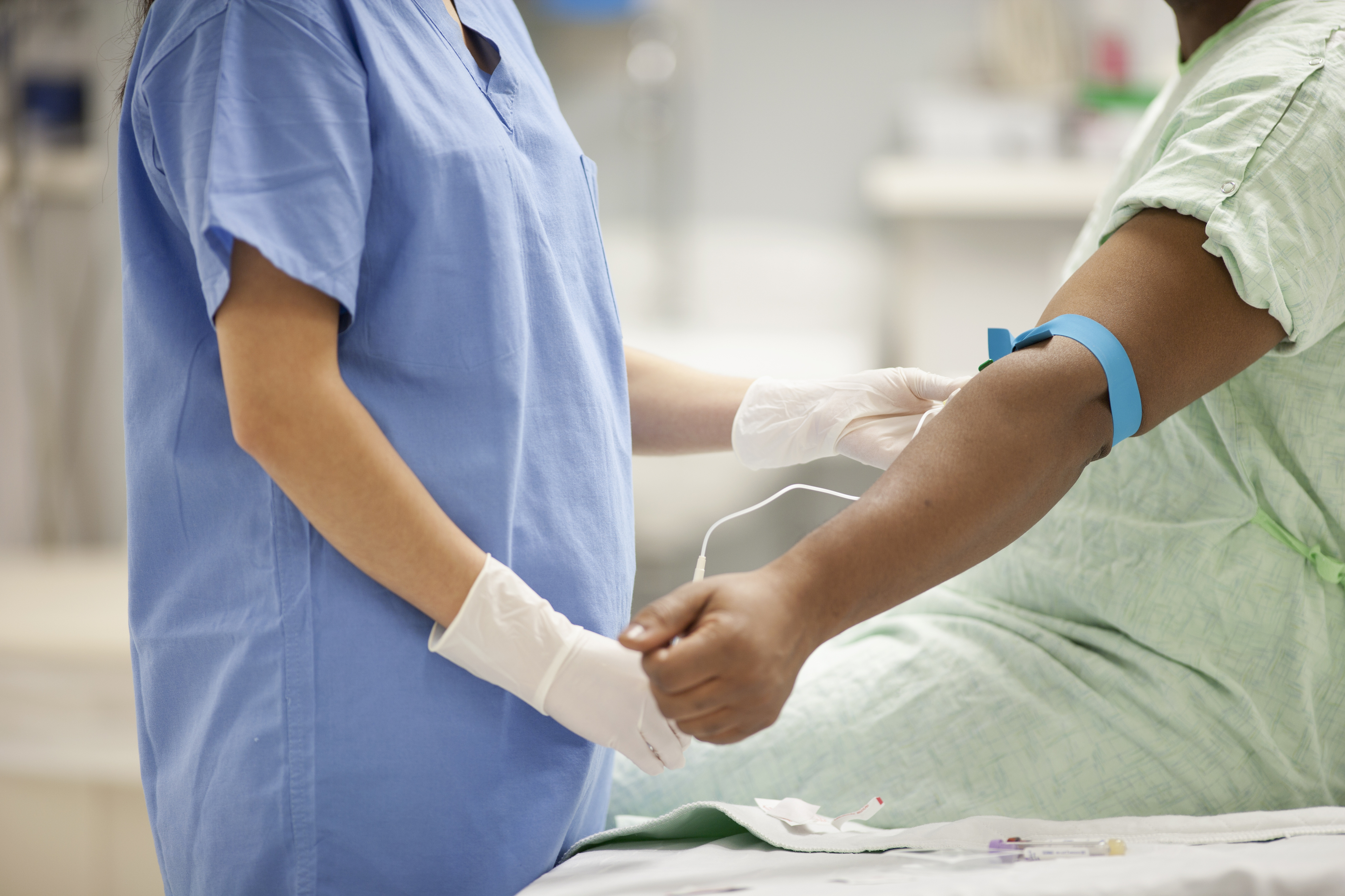 Nurse taking blood from patient in hospital