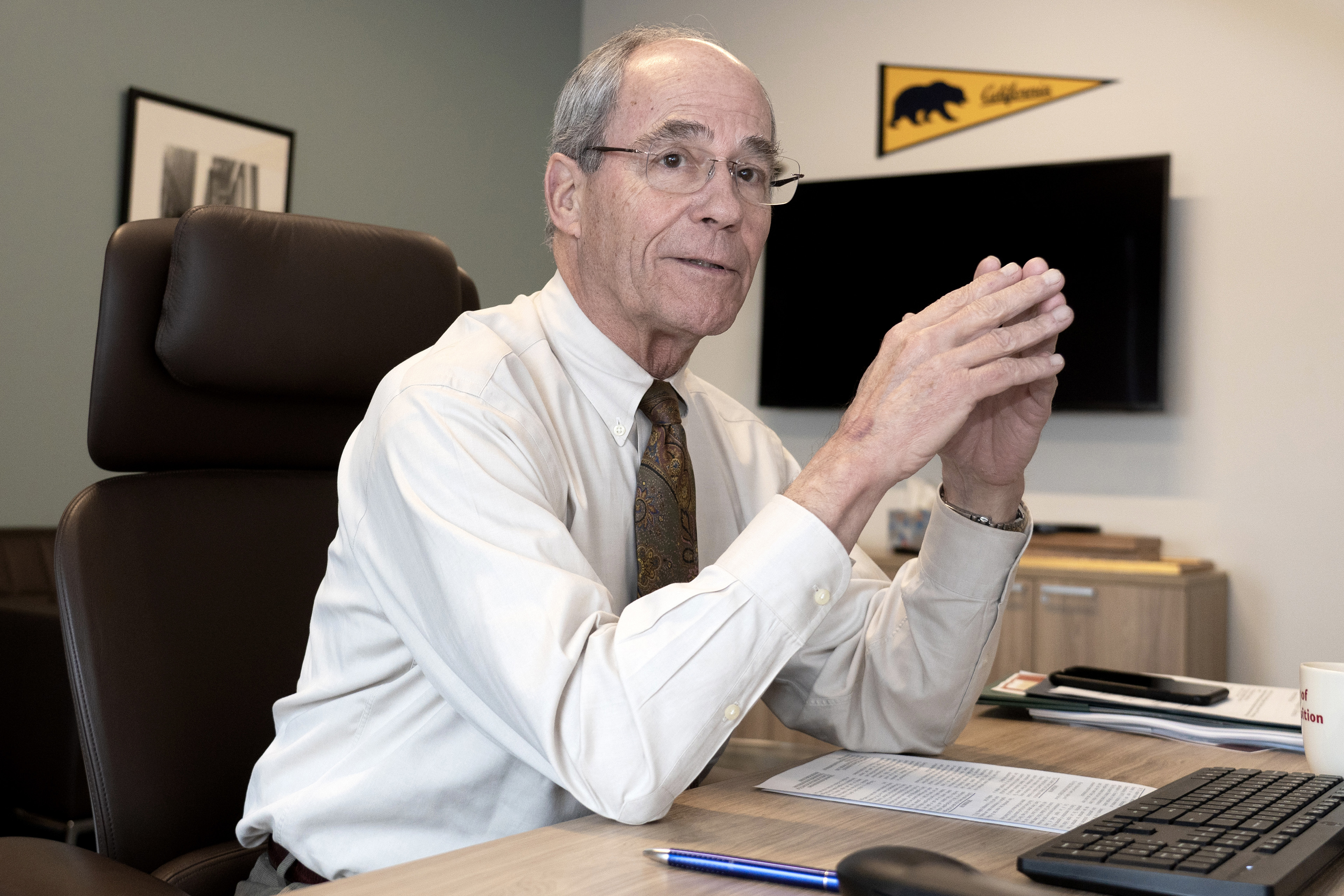 Republican state Sen. Roger Niello sits at his desk in his office. He is looking towards the camera in a friendly manner.
