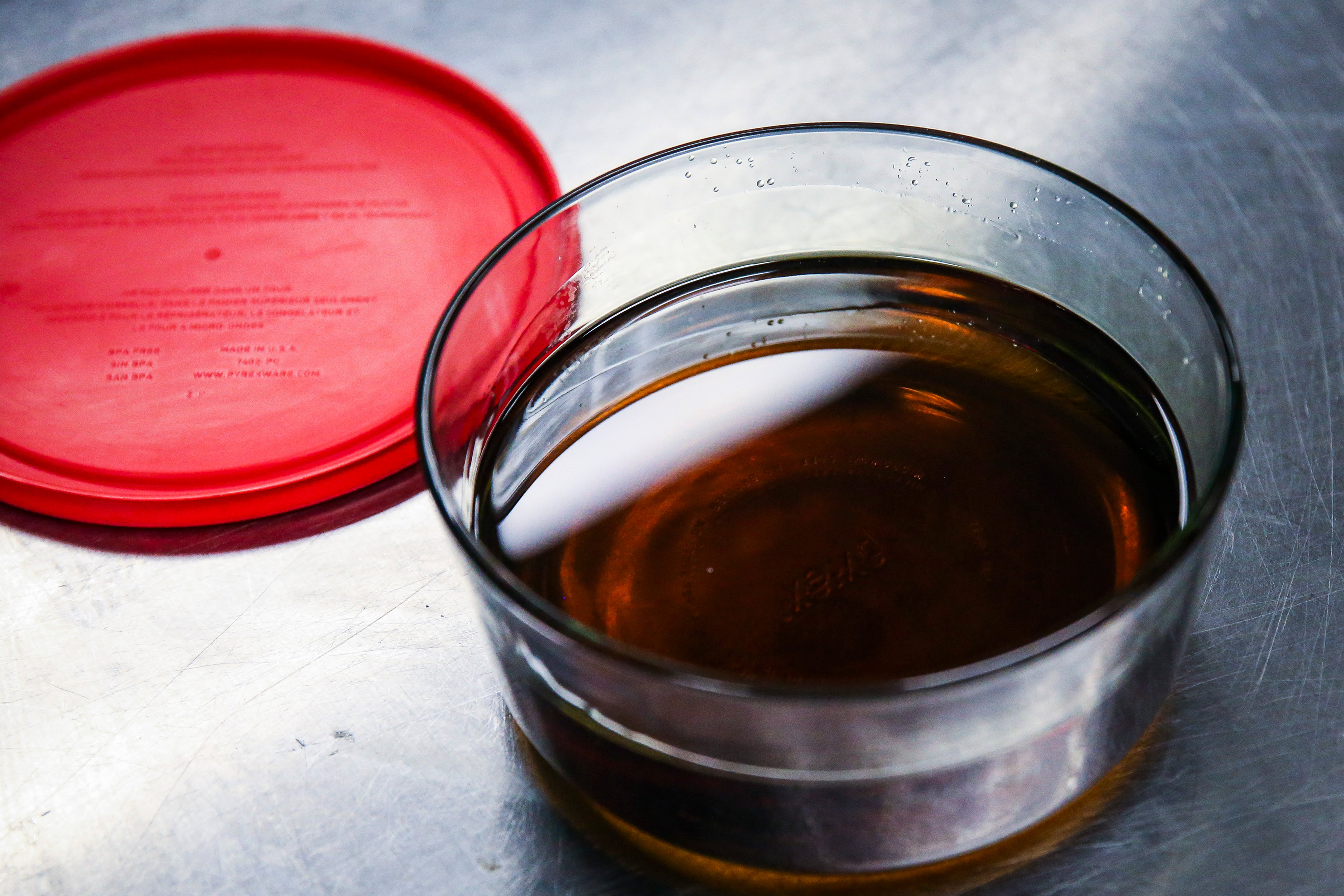 A photo of a glass container filled with liquid marijuana concentrate.