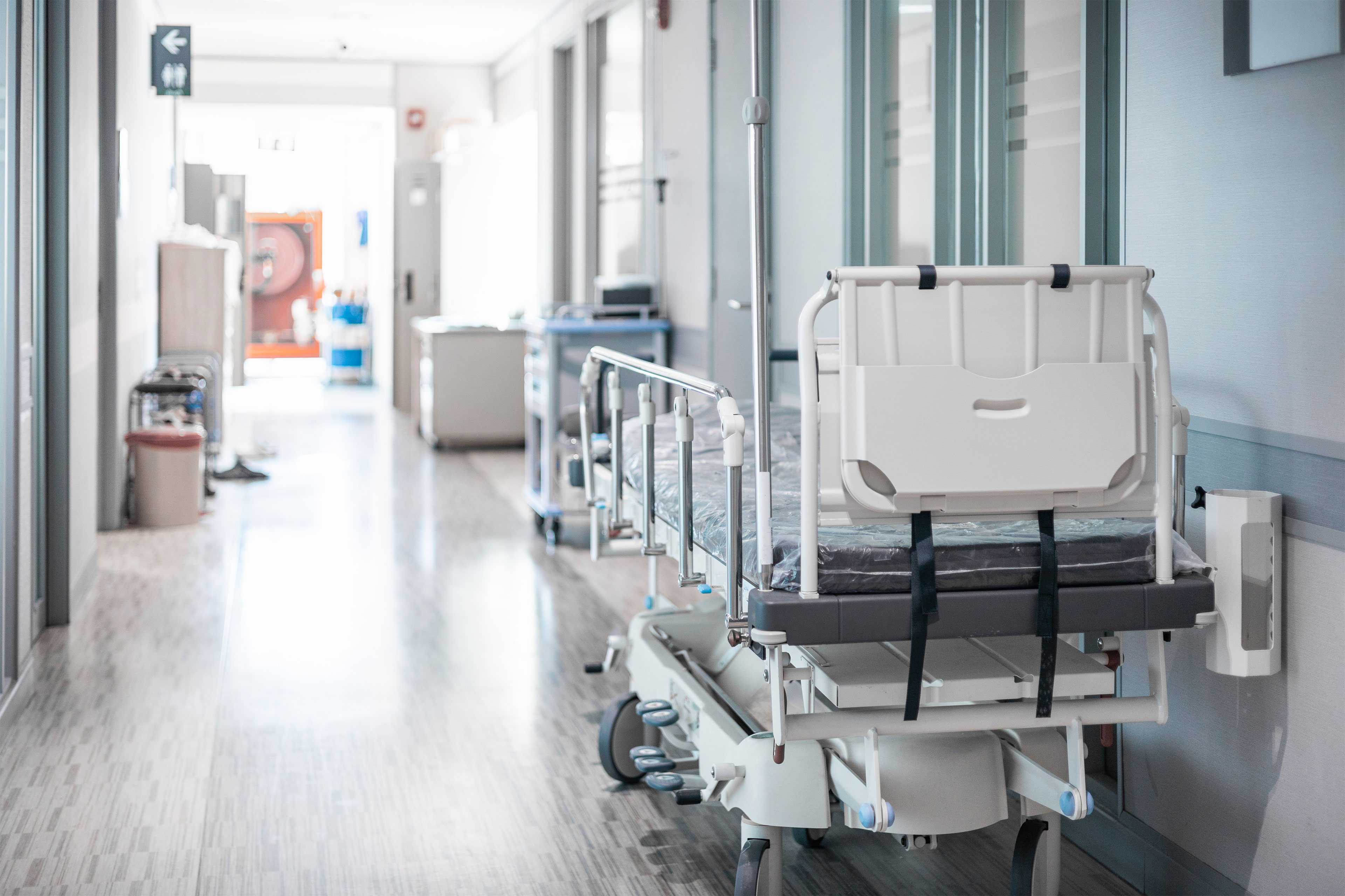 A photo of empty beds in a hospital corridor.