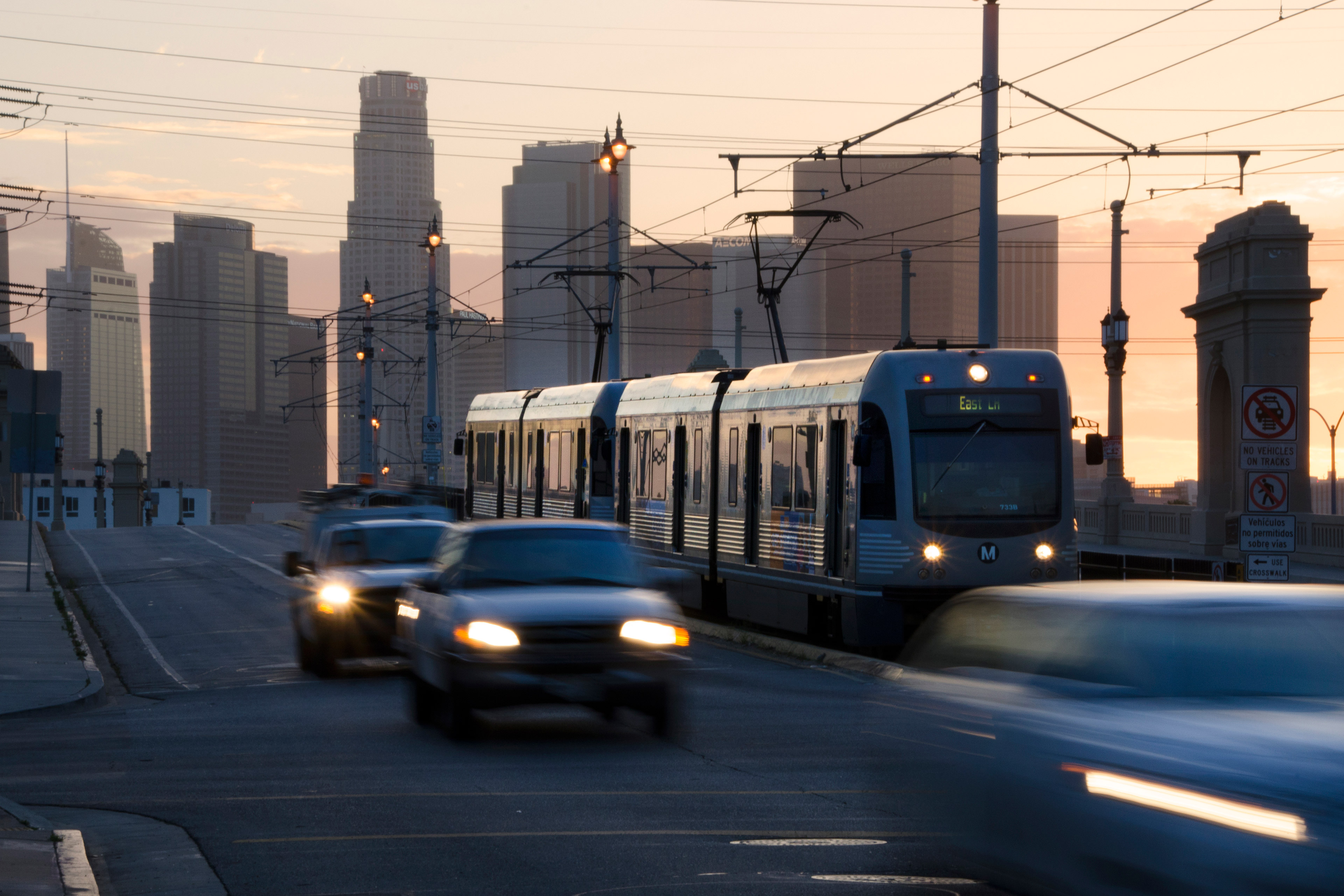 A photo of cars and a train driving by on a Los Angeles street.