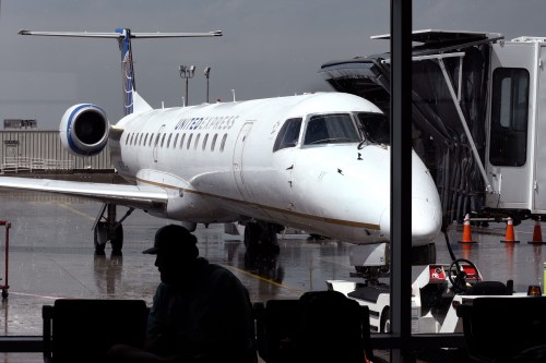 A photo of a commercial airplane seen from a window inside an airport.