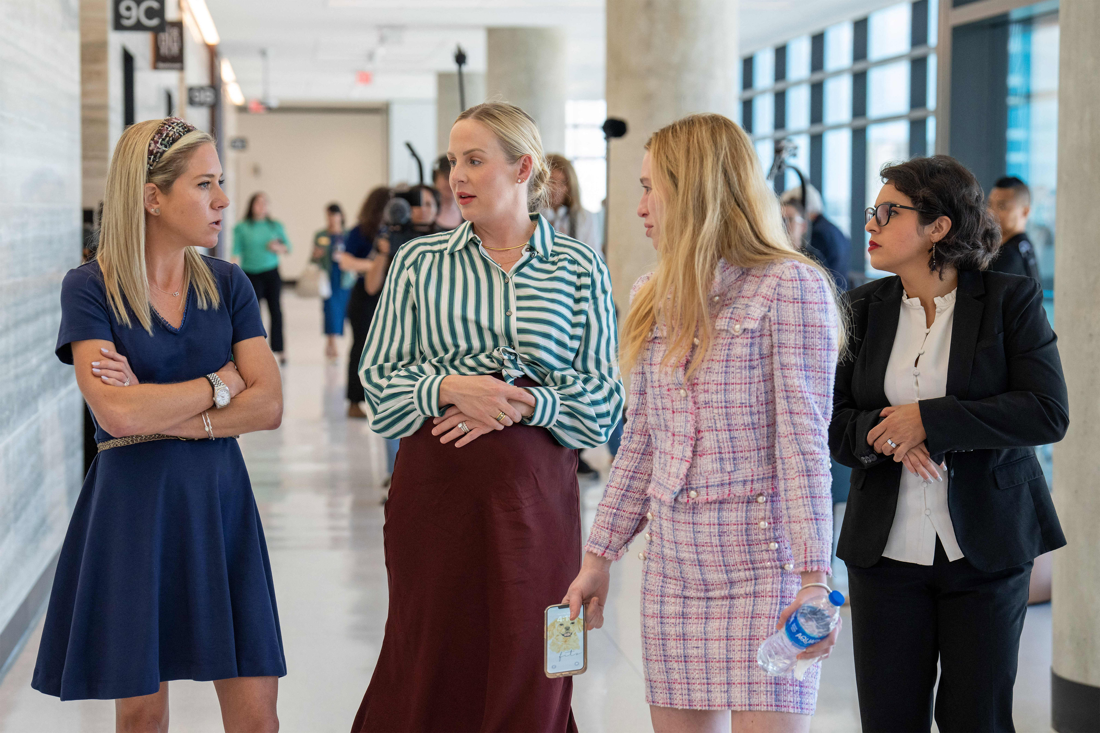 A photo of four women speaking together inside a courthouse.