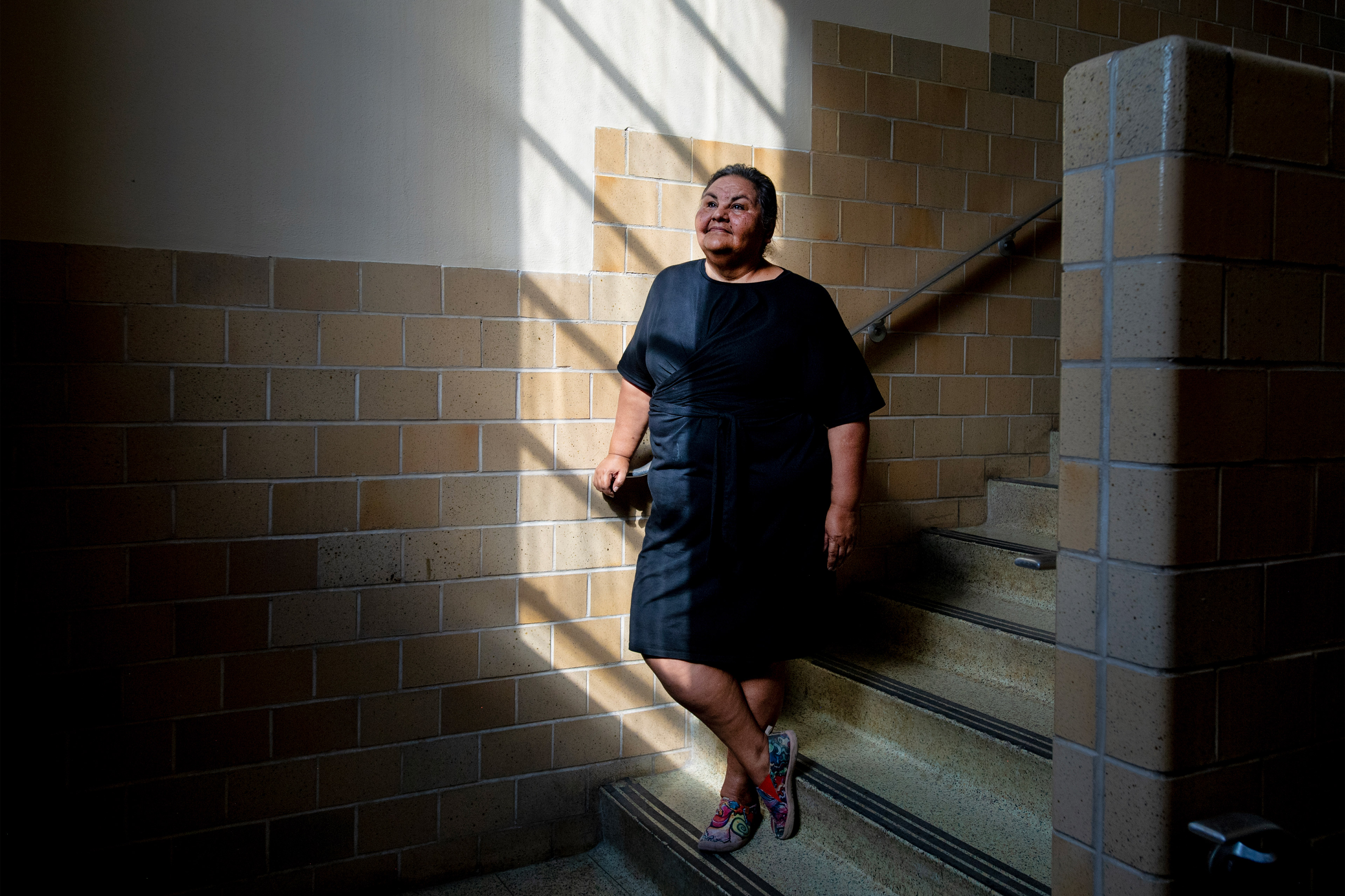 A portrait of a woman posing in a stairwell.