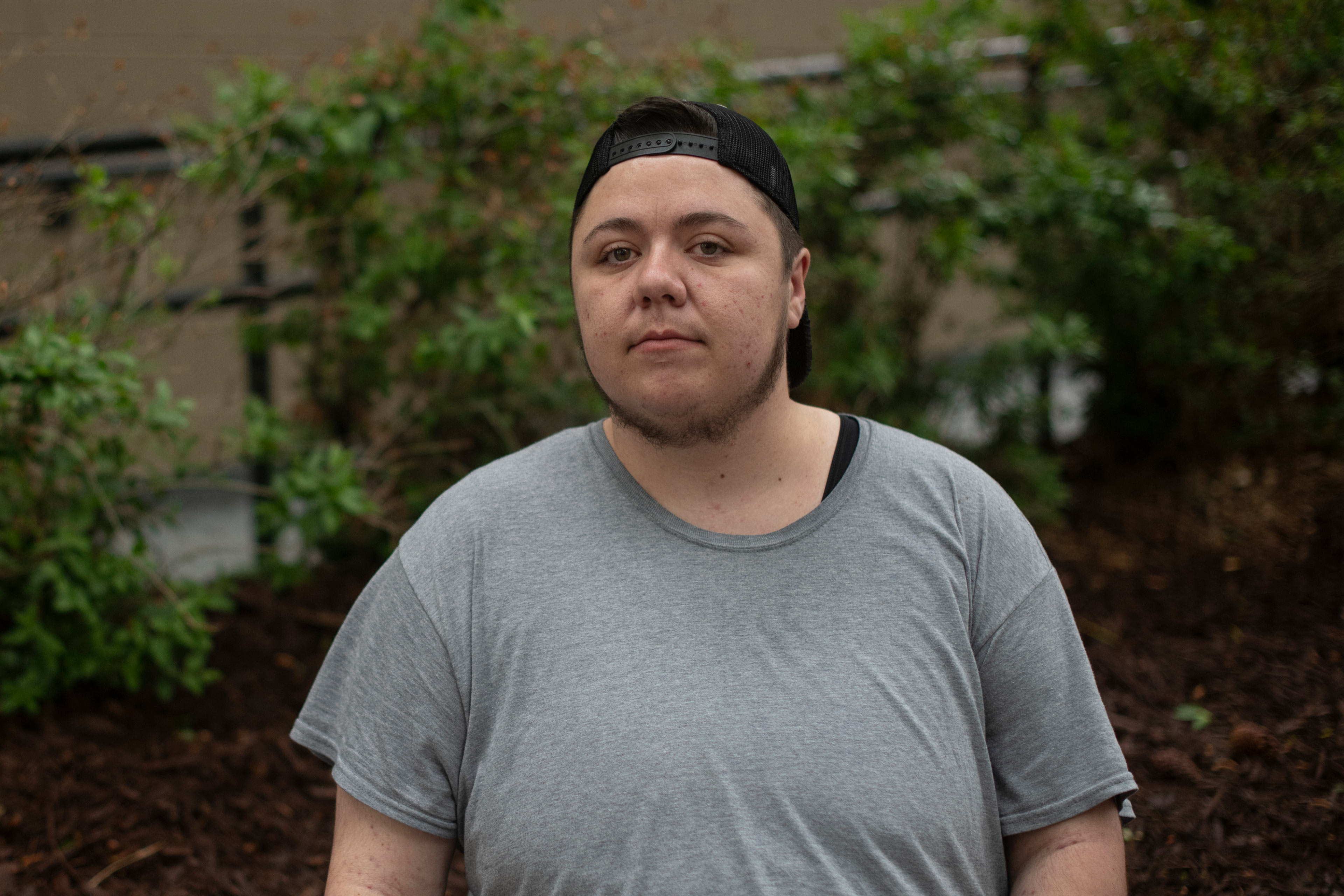 A photo of a man posing for a portrait outside.