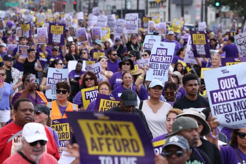 A photo of protesters holding signs in a crowd.