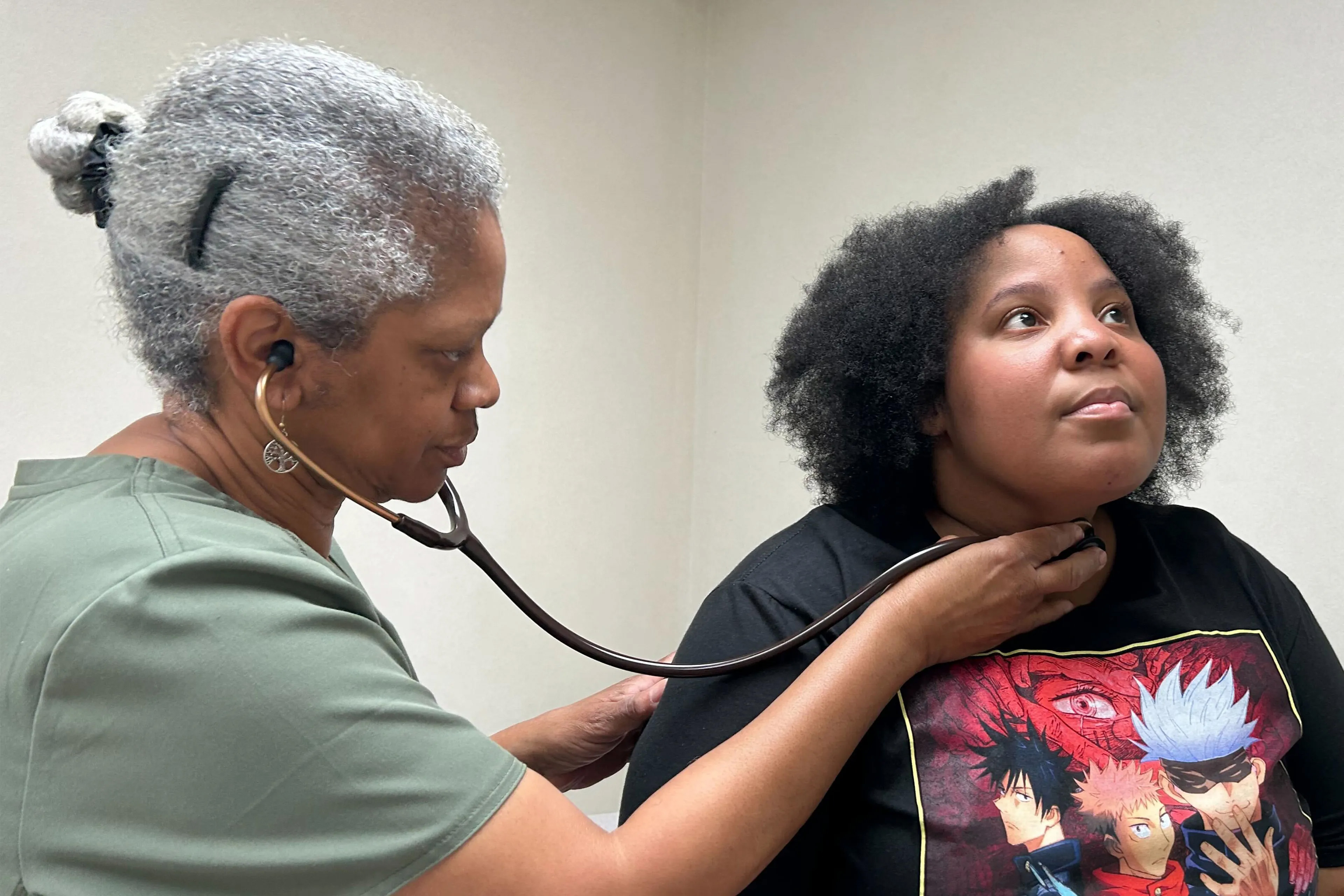 A photo of a doctor examining a female patient.