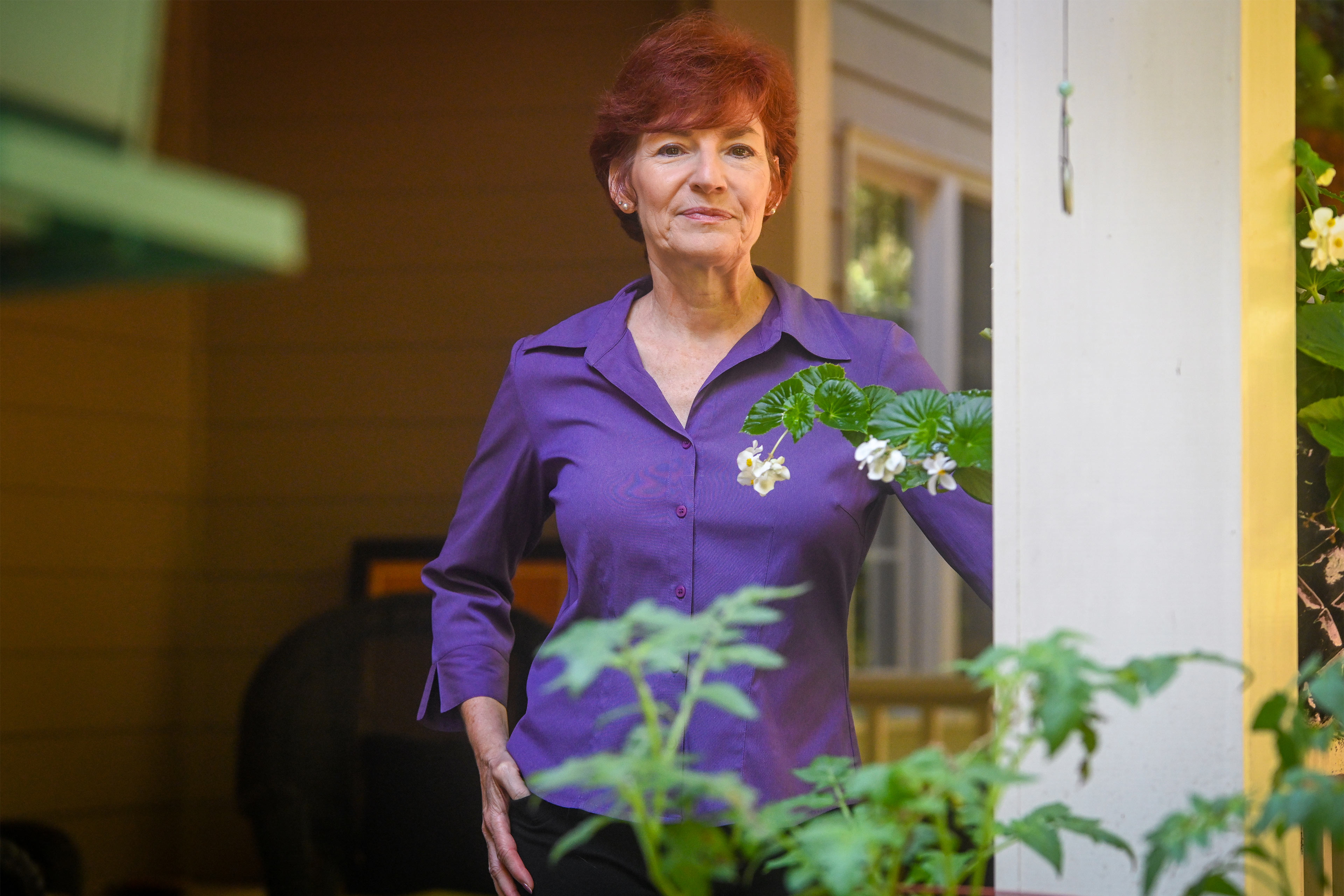 A photo of a woman posing for a portrait outside.