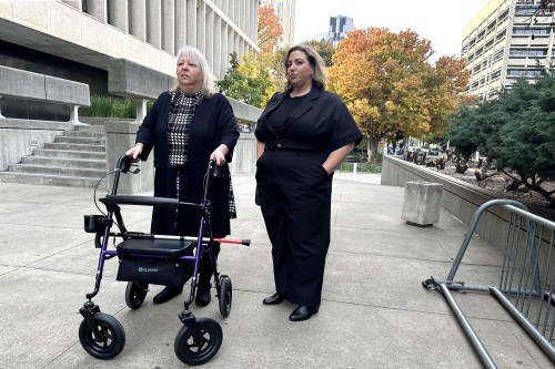 Daphne Muehlendorf stands with a walker beside one of her daughters, Terra Khan.