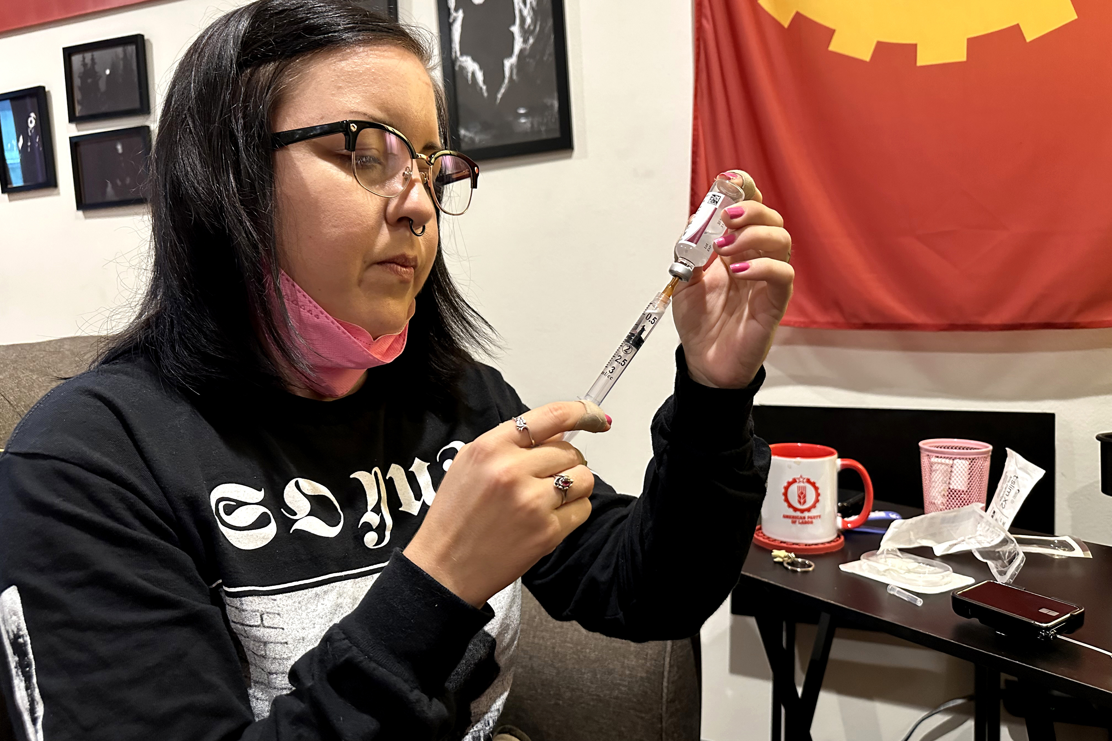 June Voros is preparing insulin by drawing fluid from a vial with a needle.