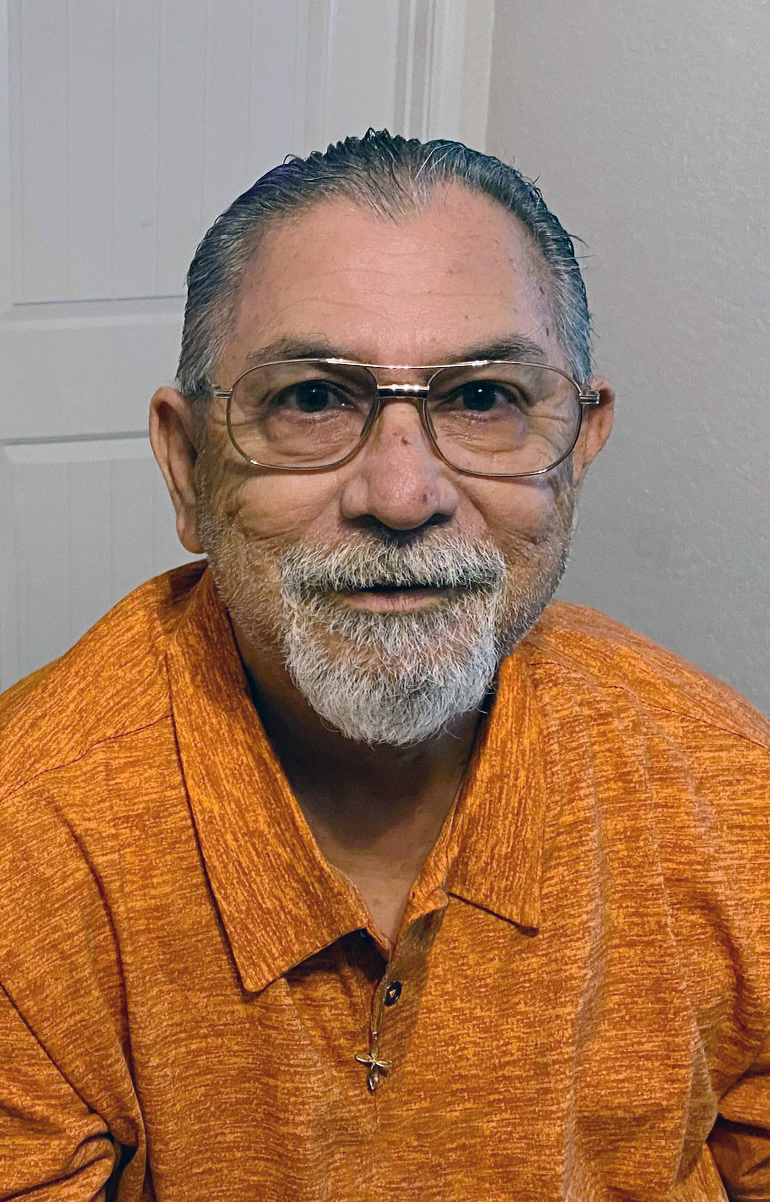 A man smiles and looks at the camera.