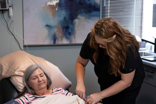 A photo of a nurse helping a woman with her ketamine treatment.