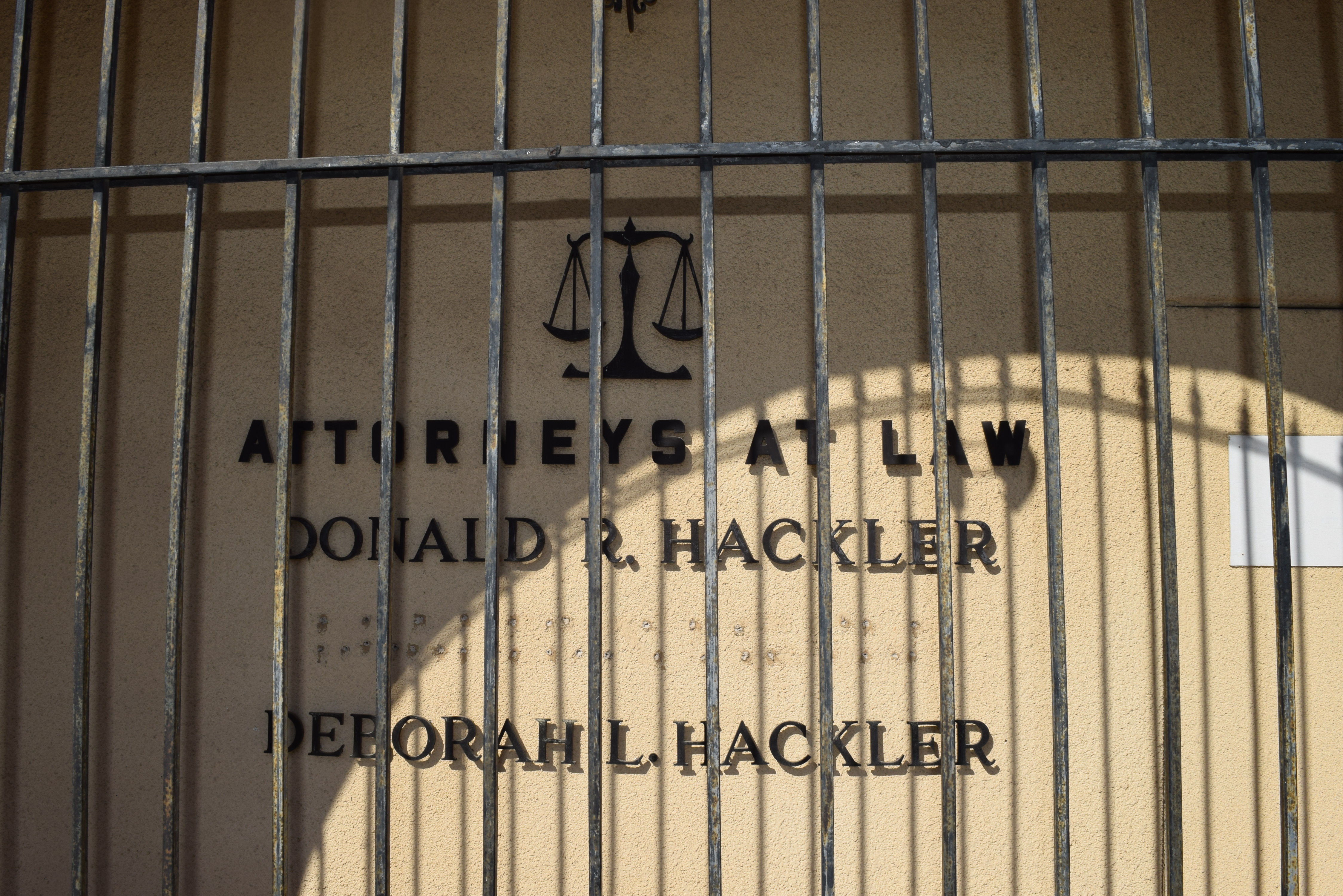 A cream wall, the front of an office, with black lettering reading "Donald R. Hackler" on one line and "Deborah L. Hackler" on another.