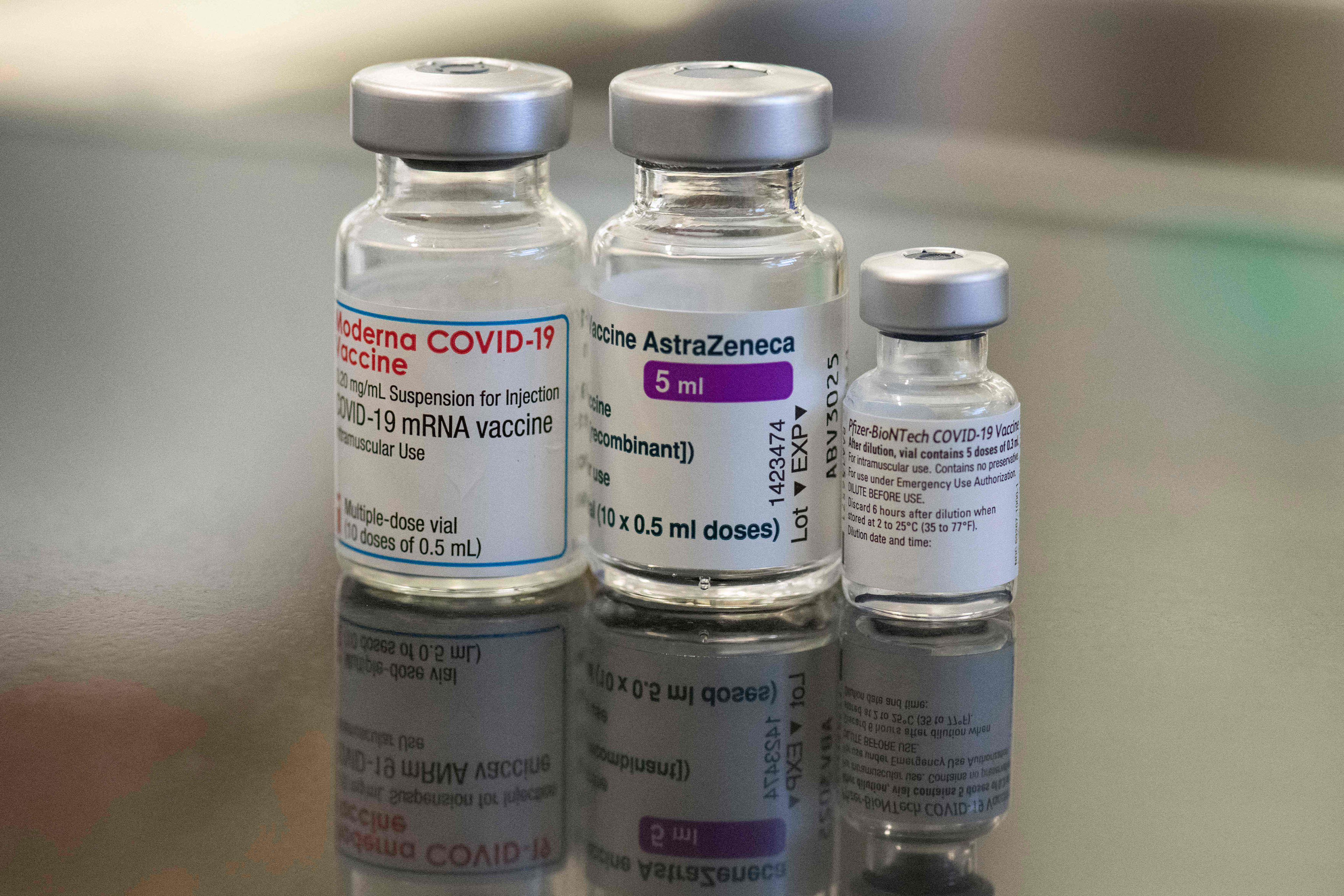 Three vials of different covid-19 vaccines, from left to right: Moderna, AstraZeneca and Pfizer-BioNTech.