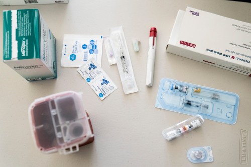 In vitro fertilization medications and sanitary products are displayed on a countertop.