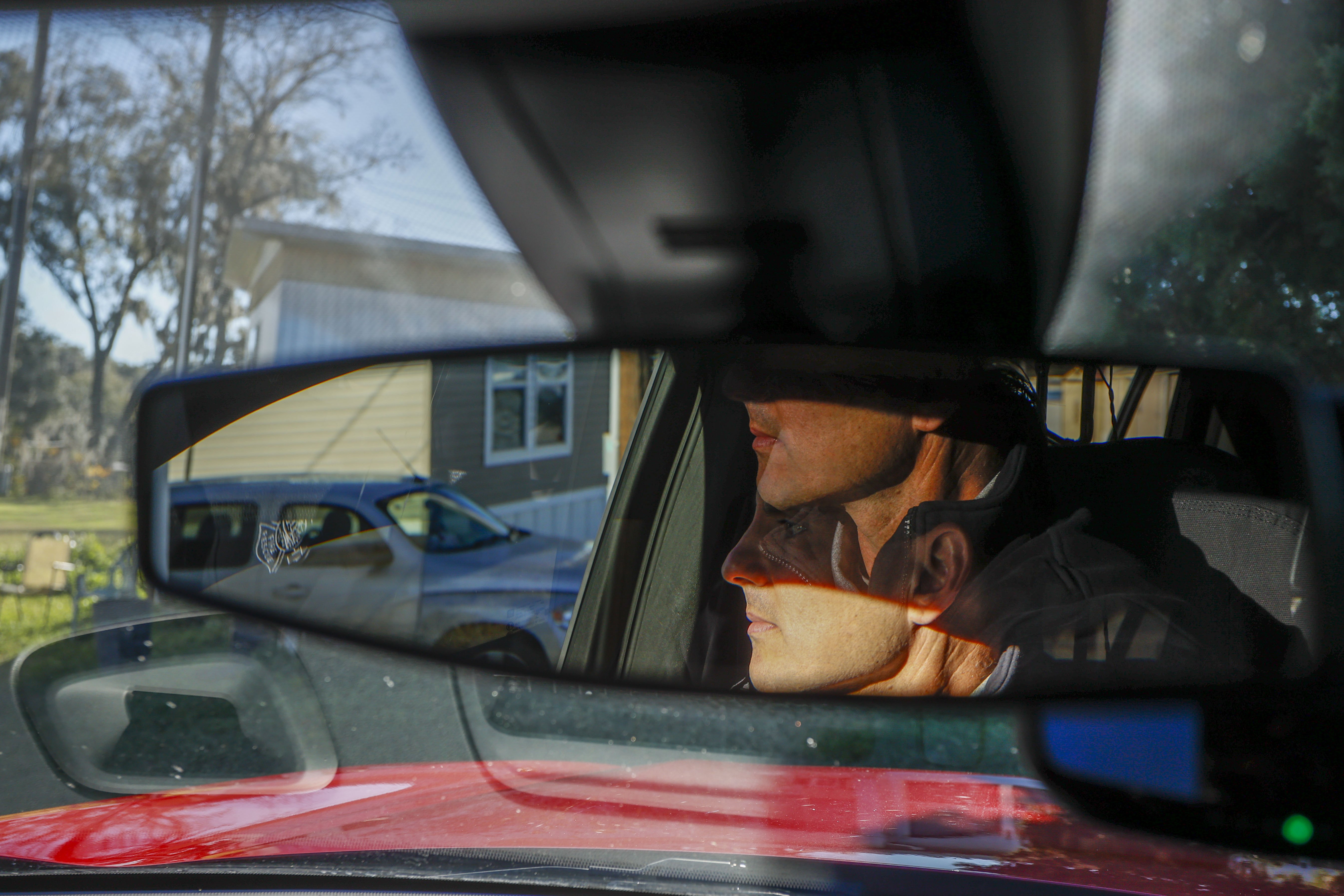 A man's face is shown in the rearview mirror of a fire truck
