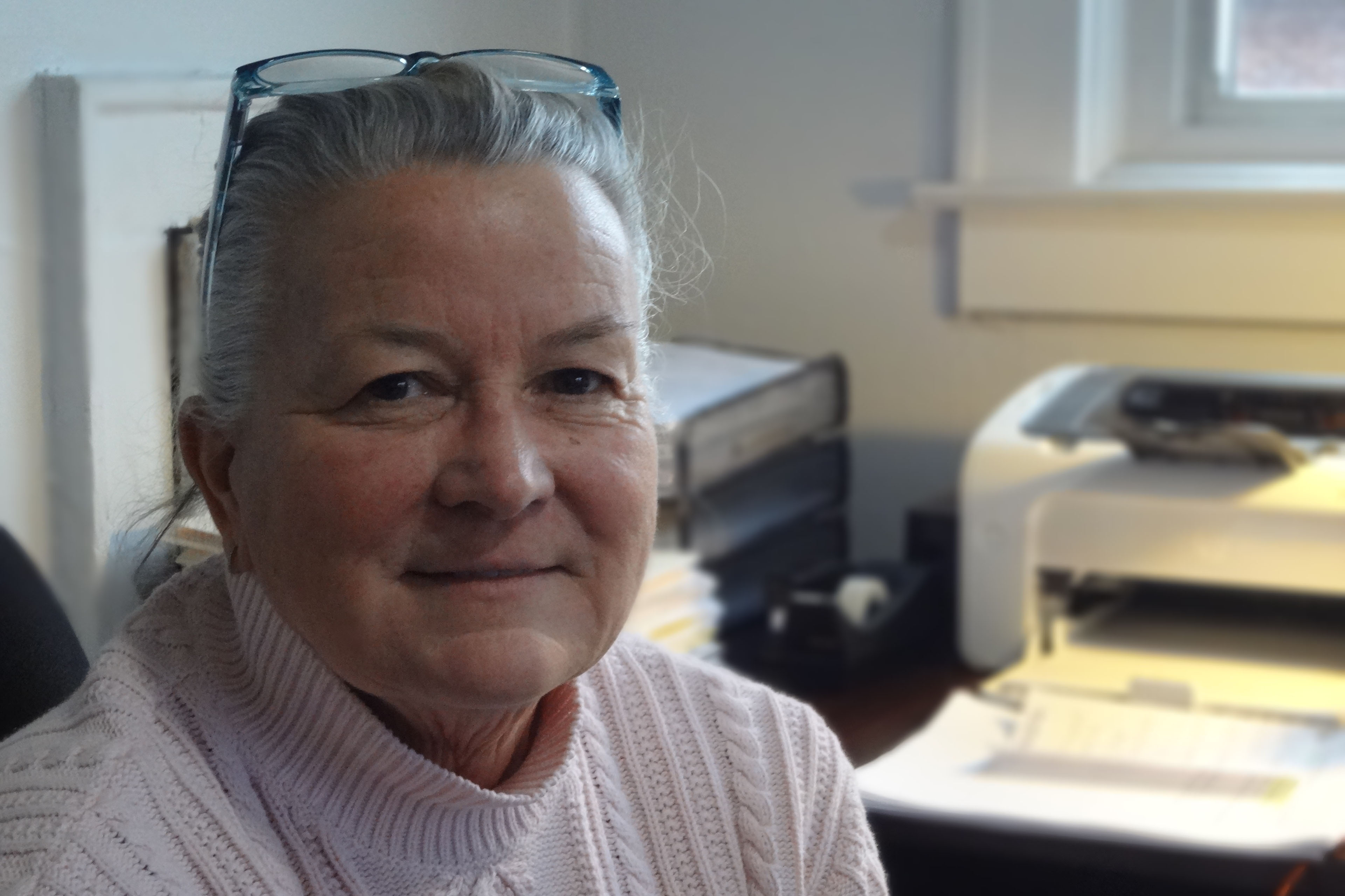 Connie Priddy looks towards the camera while she is photographed in her office.