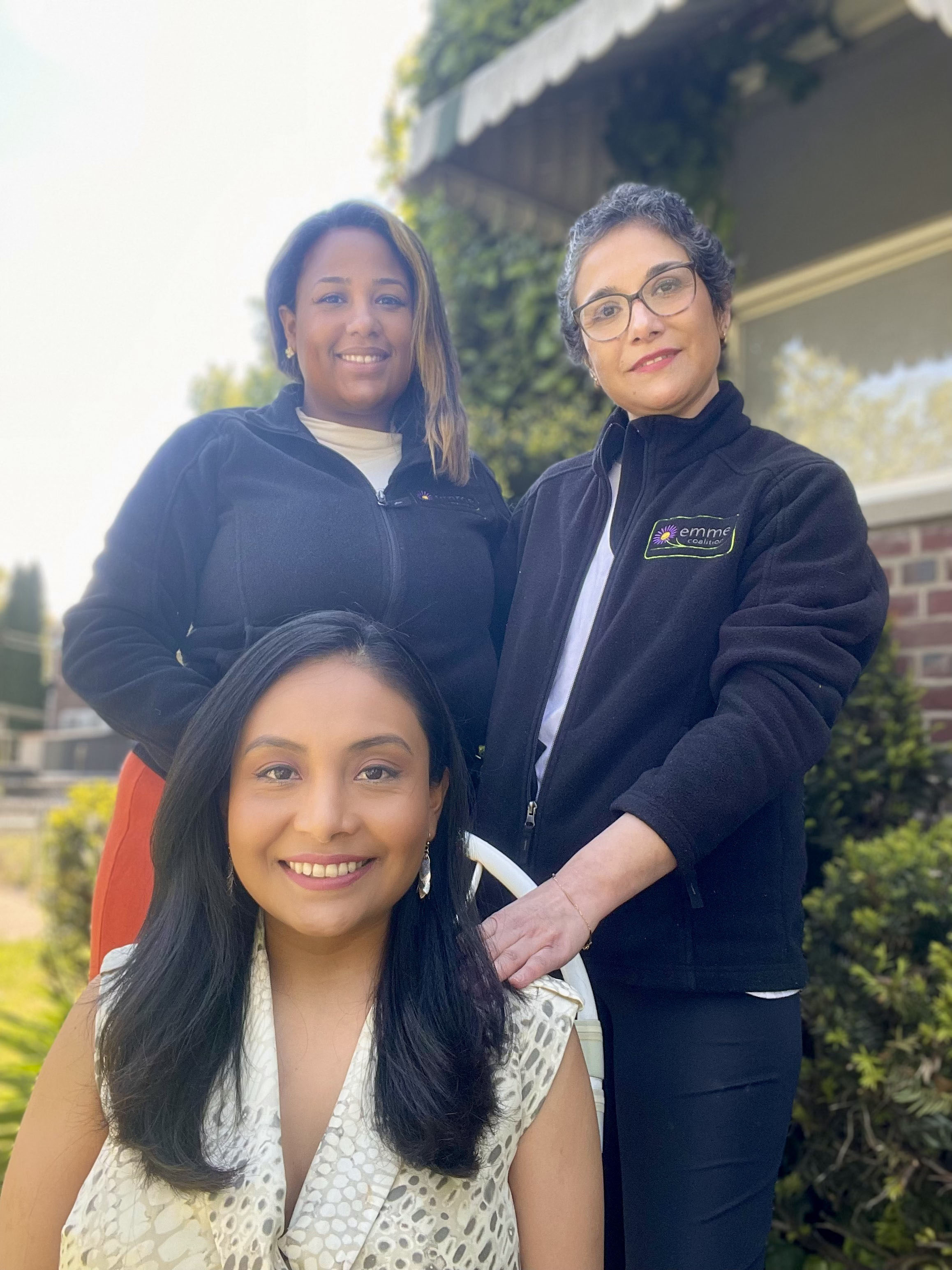 A group photo of Milagros Aquino (center, seated) with community health worker Massiel Olivo (left) and Jacqueline Carrizo (right).