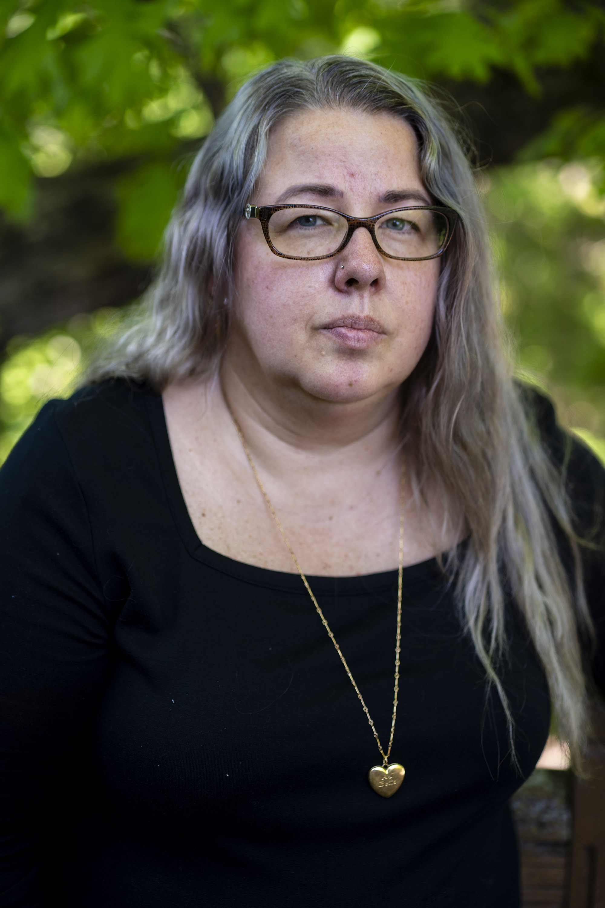 A portrait of a mother outside her home.
