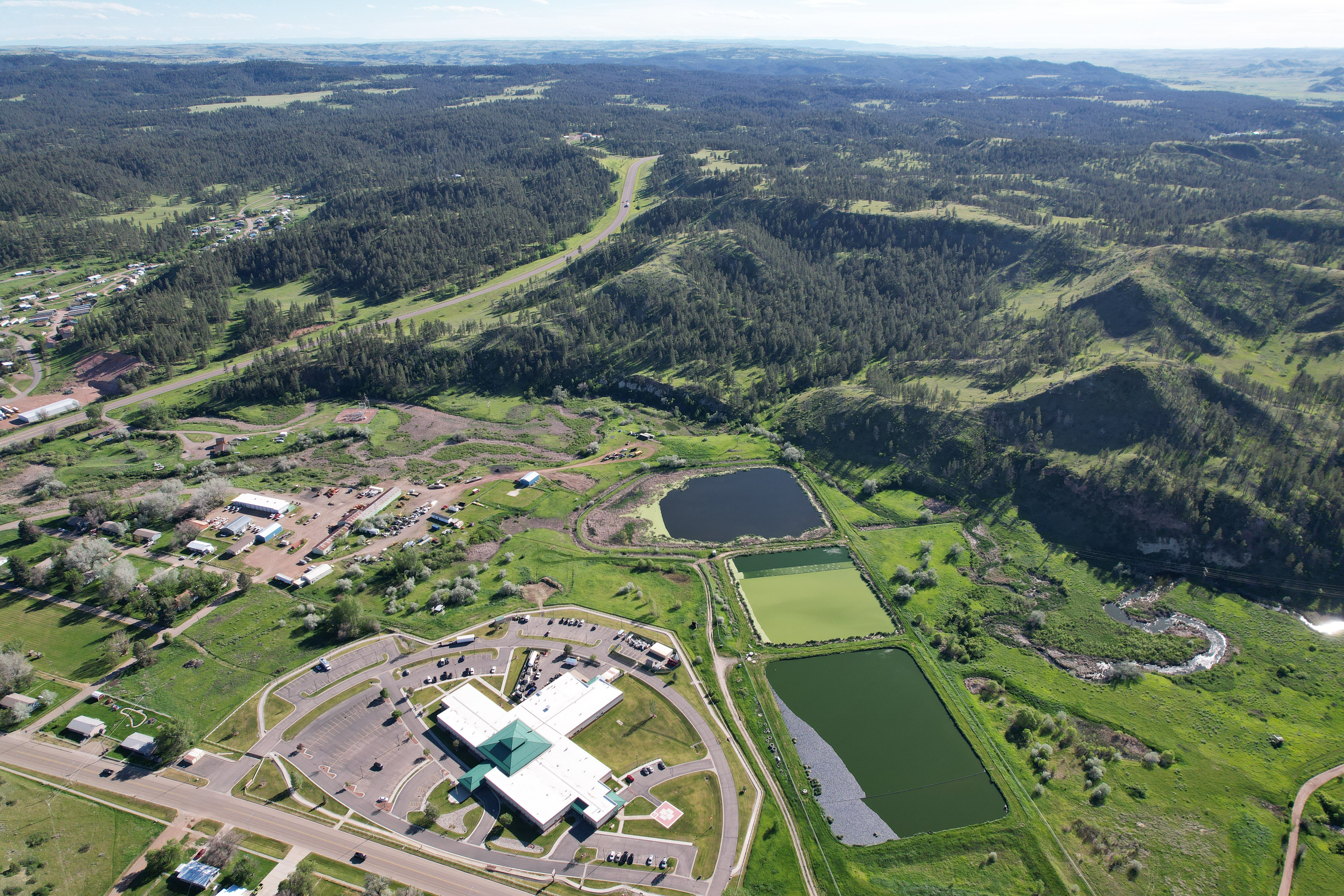 An aerial view of a small rural community in Montana. There are some buildings and large swathes of greenery. 