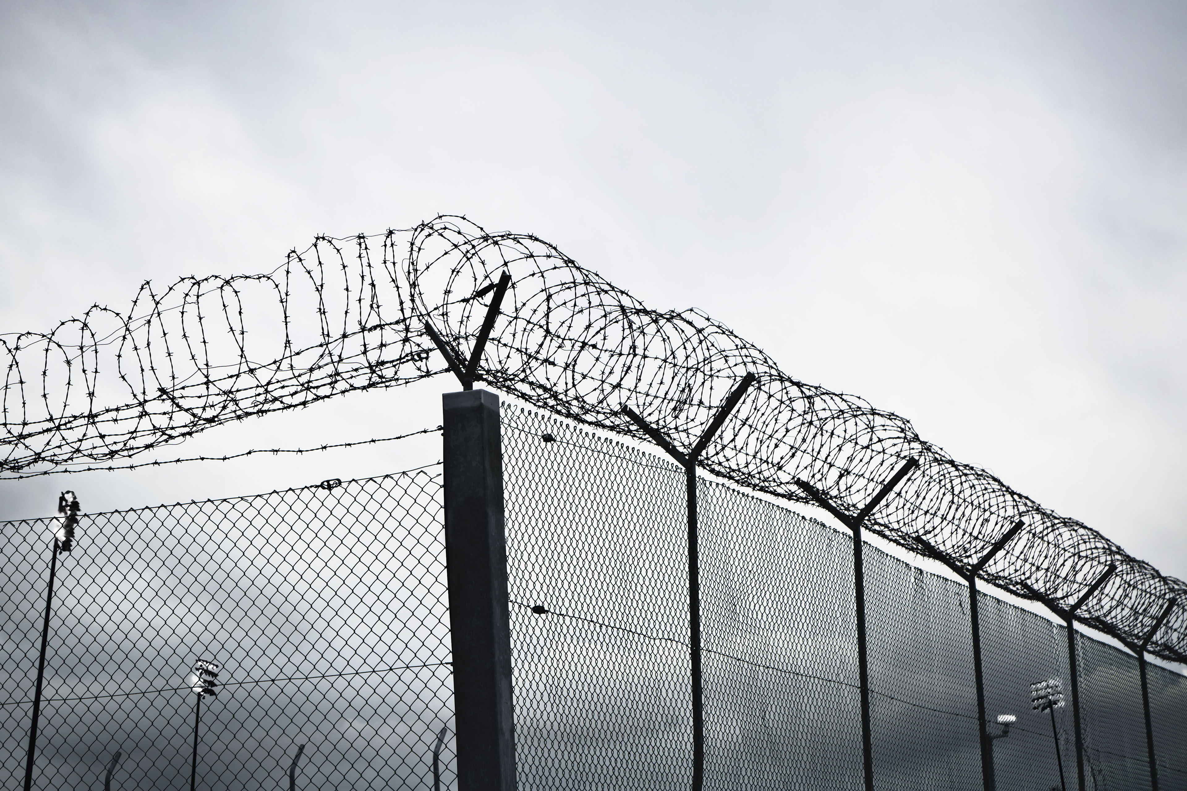 A chain link fence with barbed wire at the top