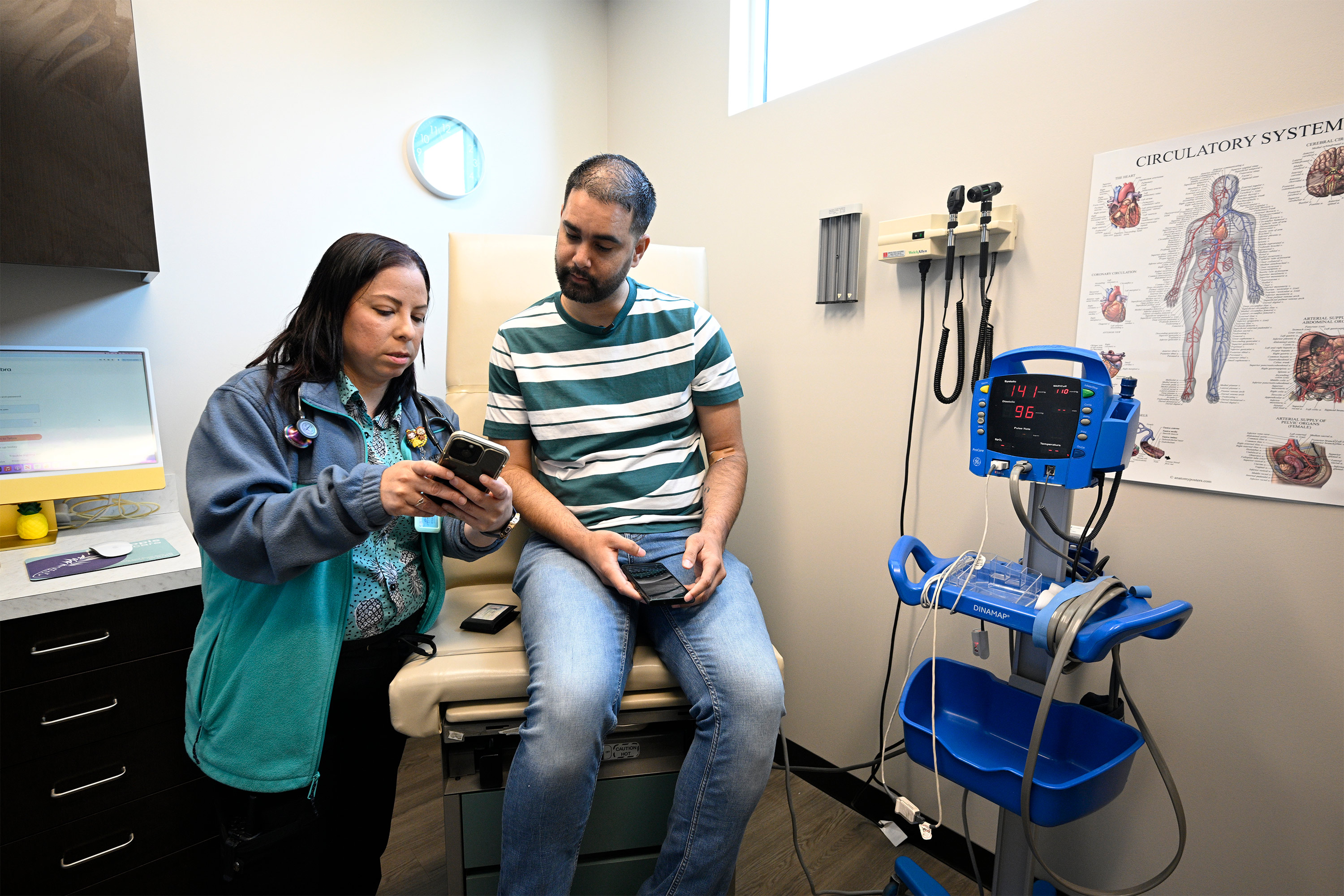 A photo of a nurse showing a patient something on her phone.
