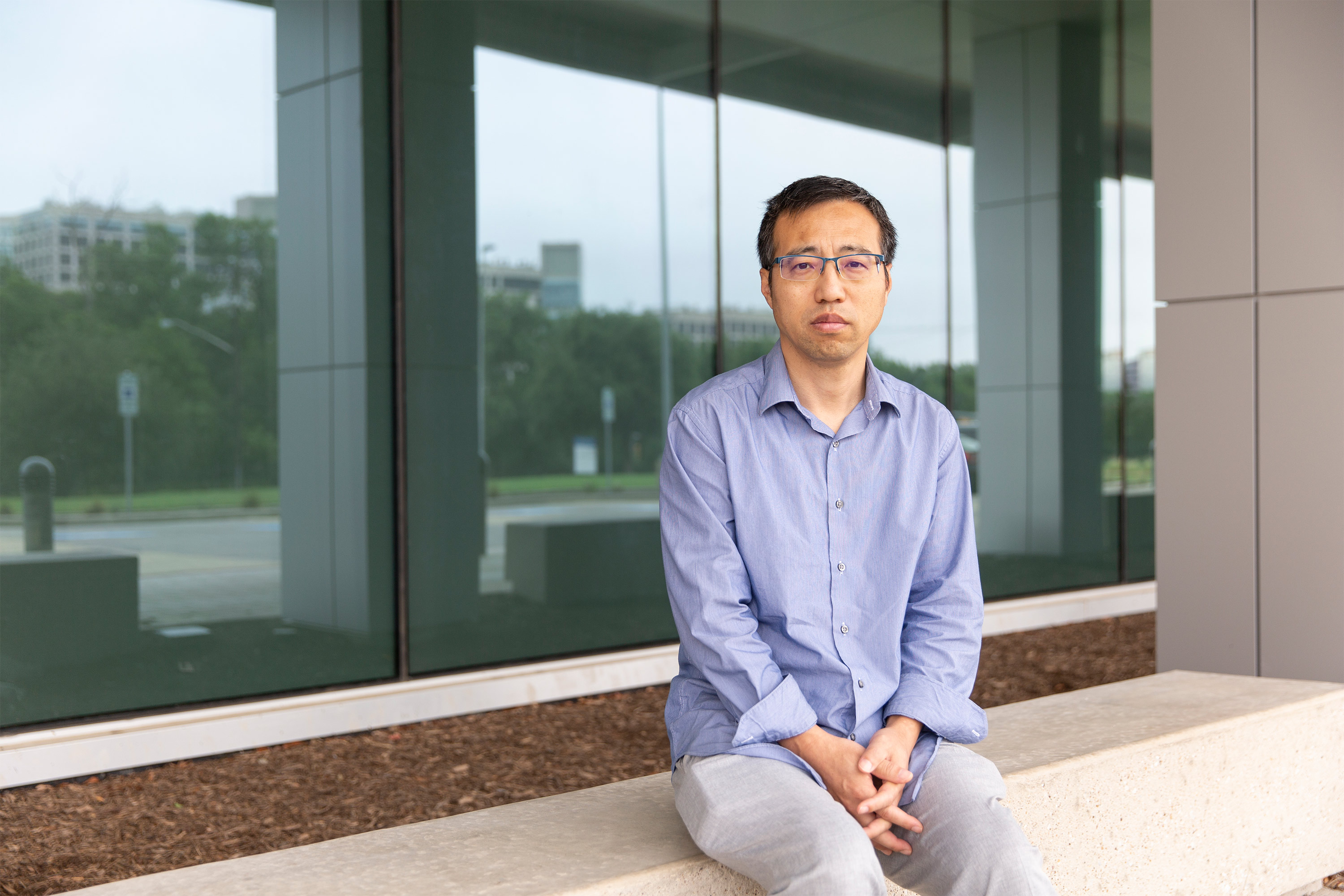 A portrait of a man sitting outside.