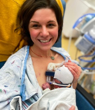 A woman with short brown hair holds a baby on her chest in a hospital bed