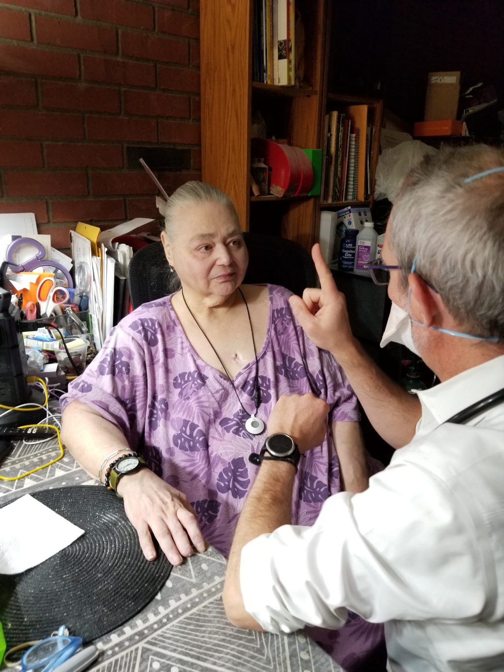 A doctor performs a visual exam on a senior female patient