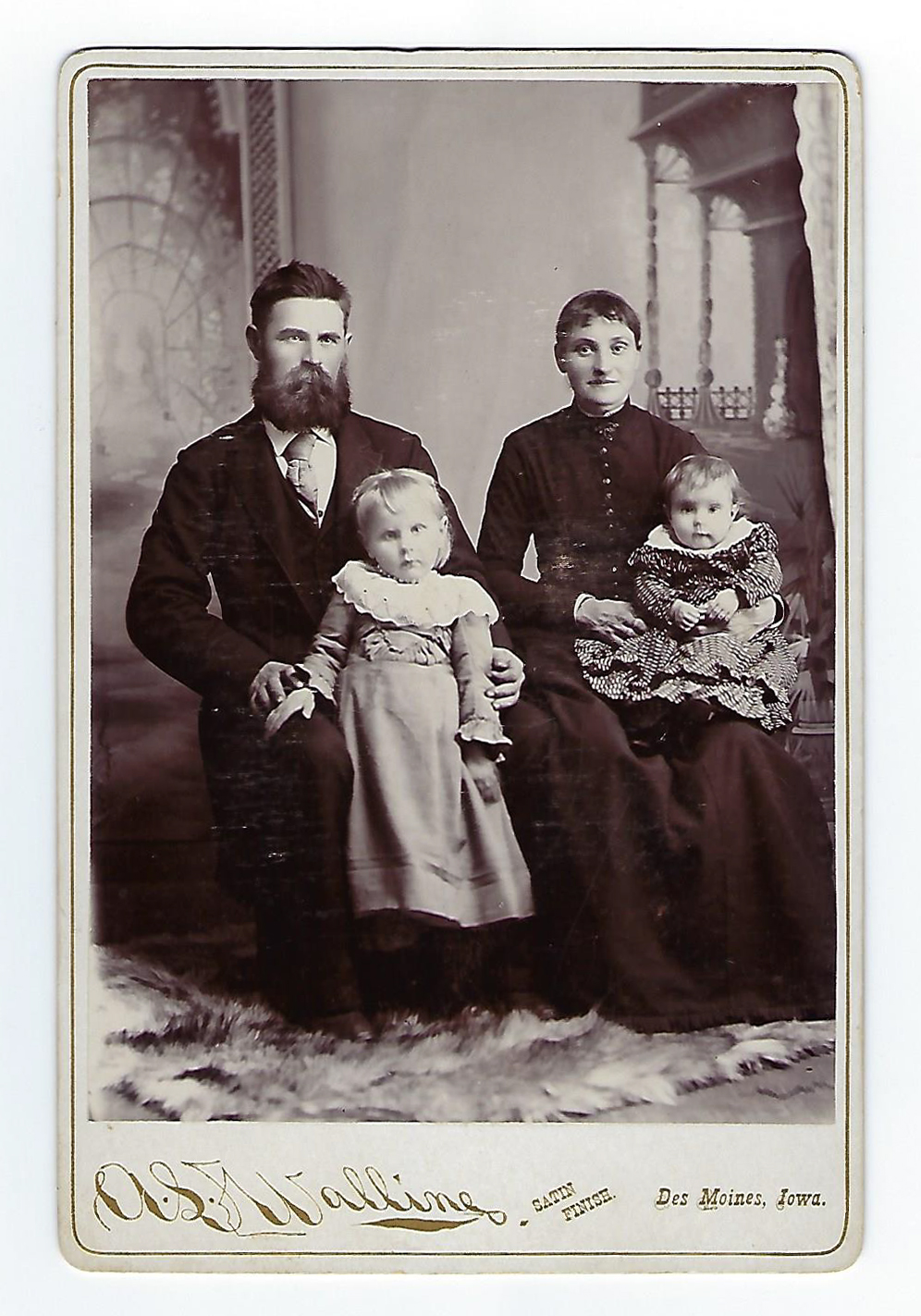 An archival photo of a husband and wife seated with two young daughters.