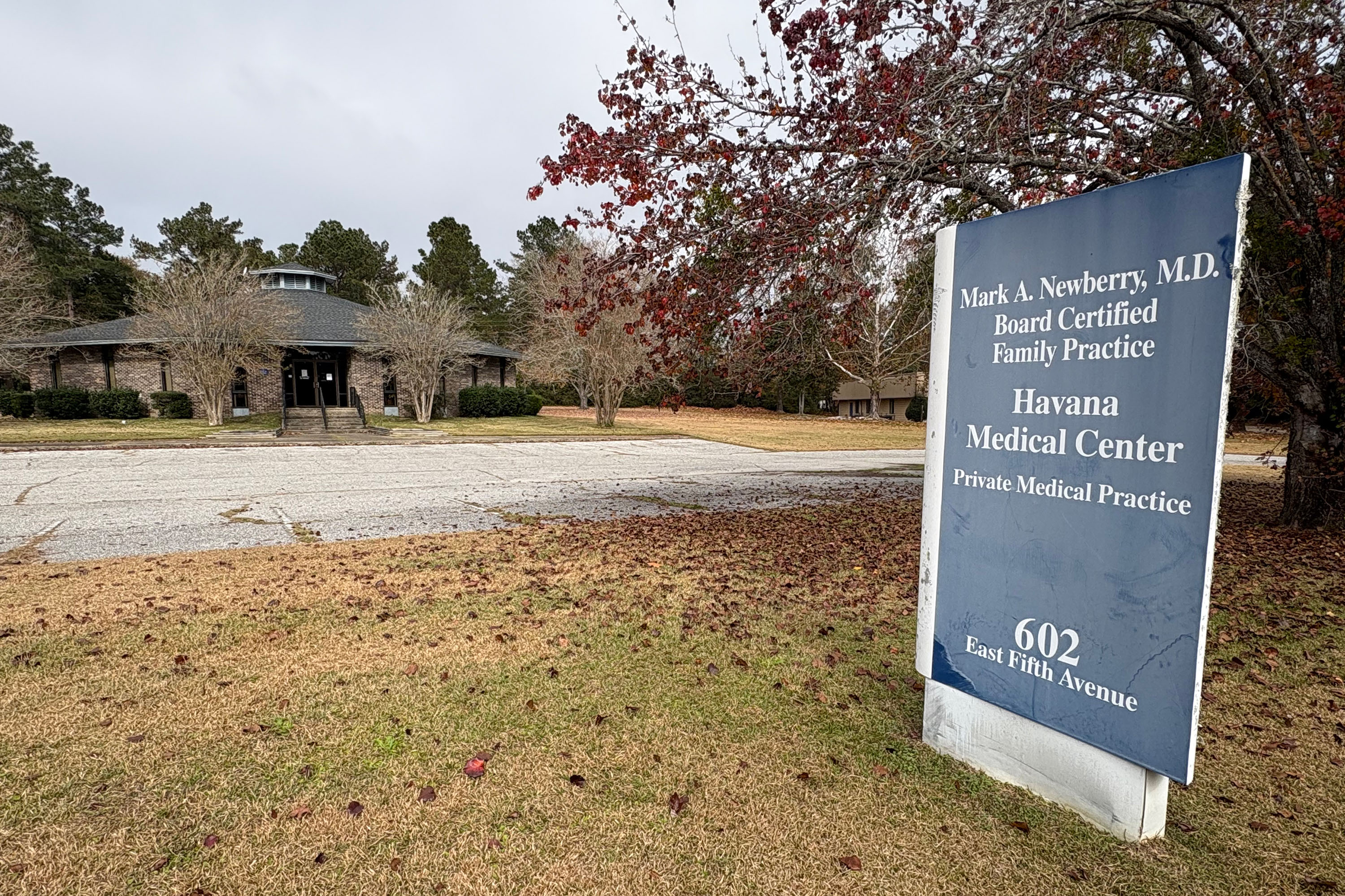A photograph showing the exterior of the Havana Medical Center building on an autumn day. In the foreground is a sign that reads, "Mark A. Newberry, M.D. / Board Certified Family Practice / Havana Medical Center / Private Medical Practice."