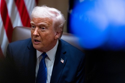 A photo of President Trump sitting in a chair in a conference room in the White House.