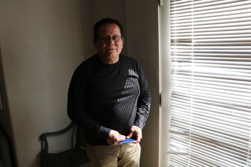 A photo of a man of Nicaraguan descent standing by a window indoors for a portrait.