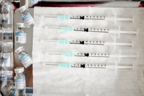 A photo of a tray of syringes and vaccine vials.