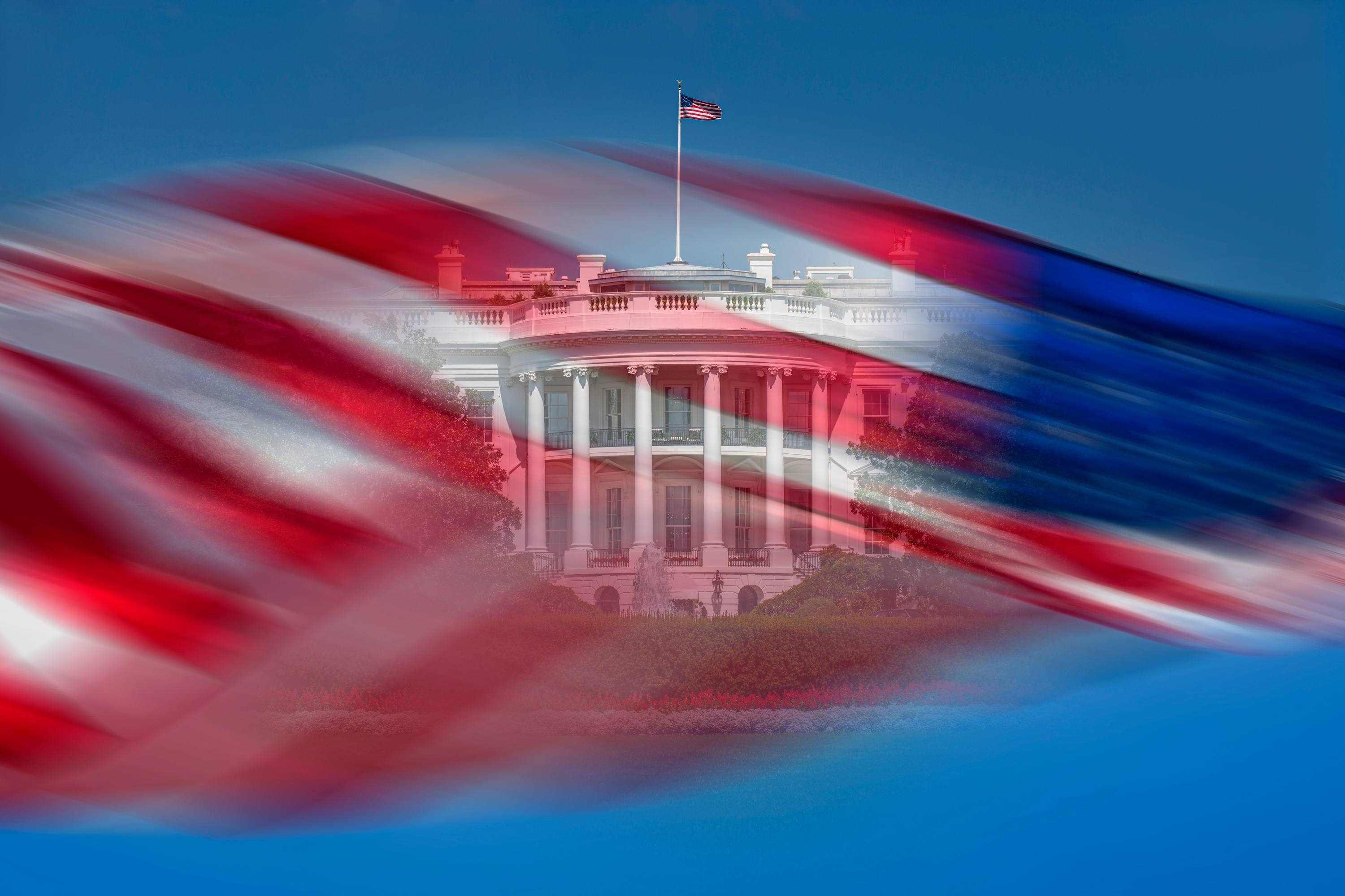 A photo illustration shows the exterior of the White House seen behind a blurred picture of an American flag waving in the wind against a blue sky.