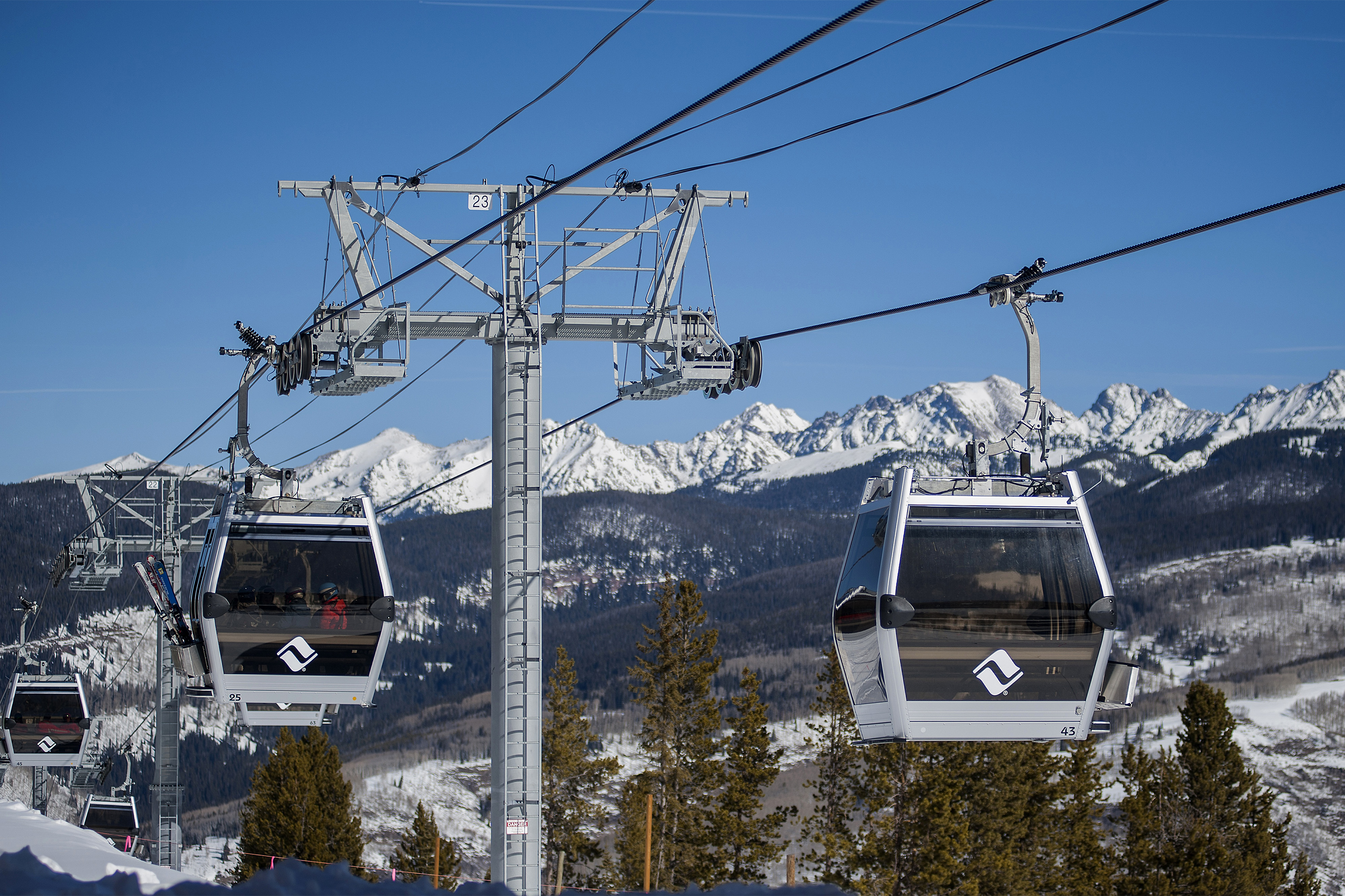 A photo of gondolas on cables at a ski resort.