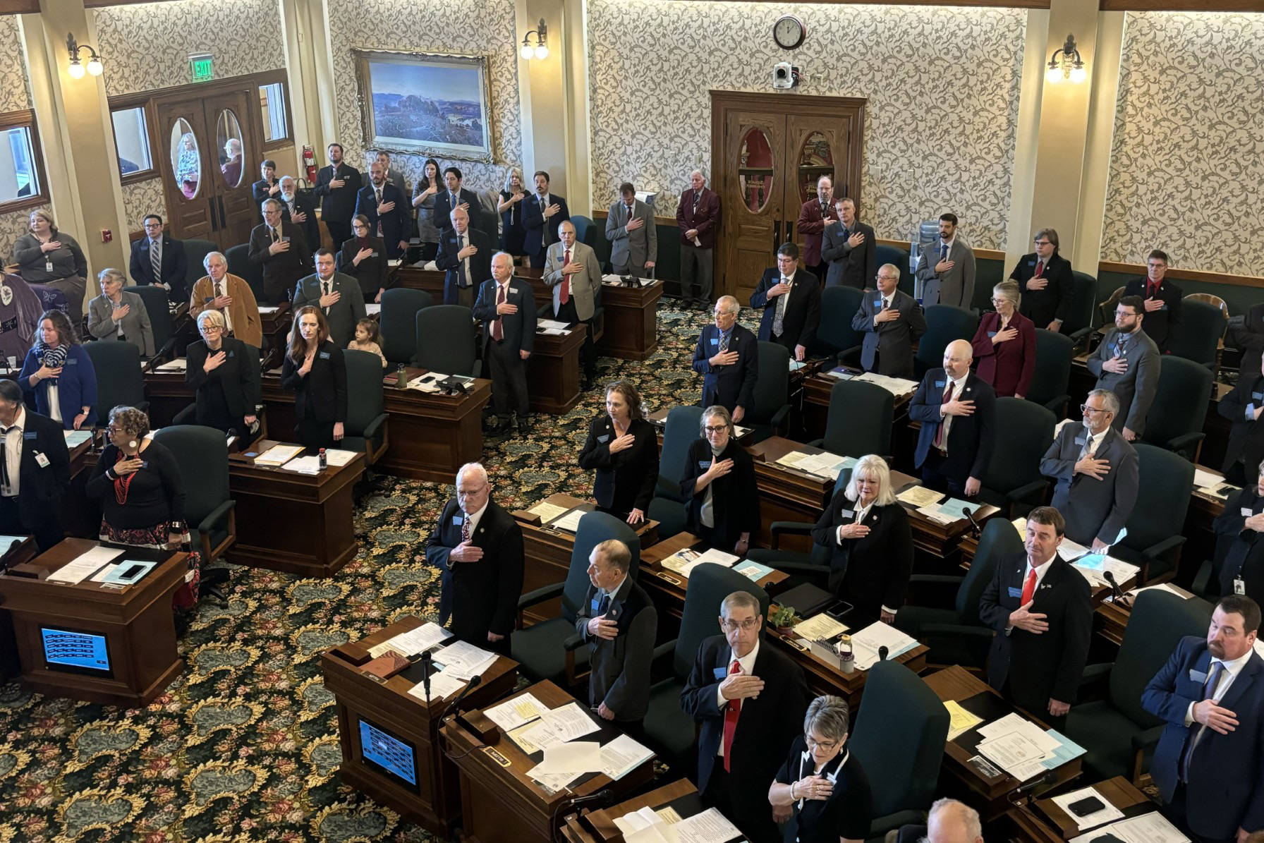 A photo of members standing on the Montana Senate floor.