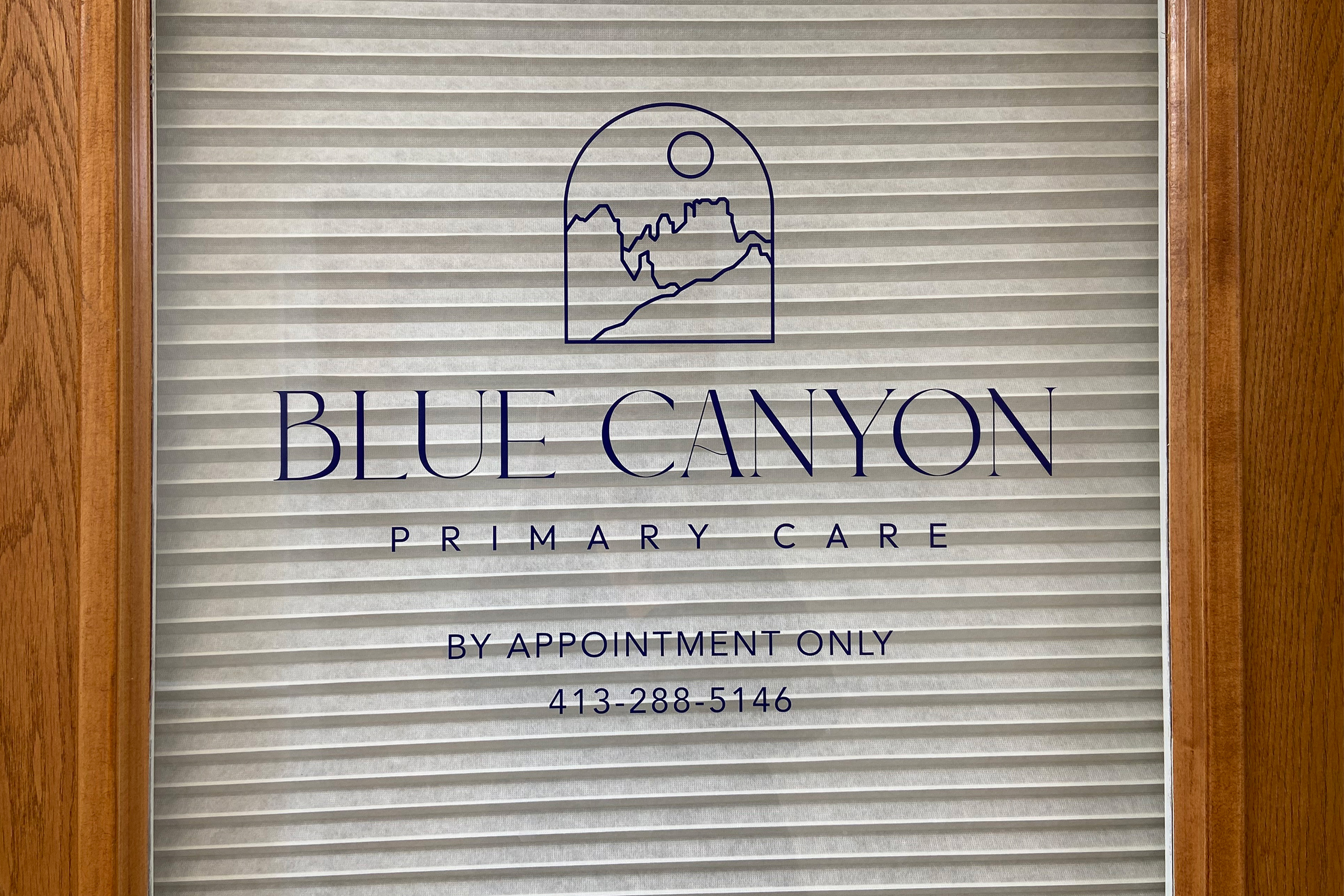 A photo of a sign for Blue Canyon Primary Care shown printed on a door.