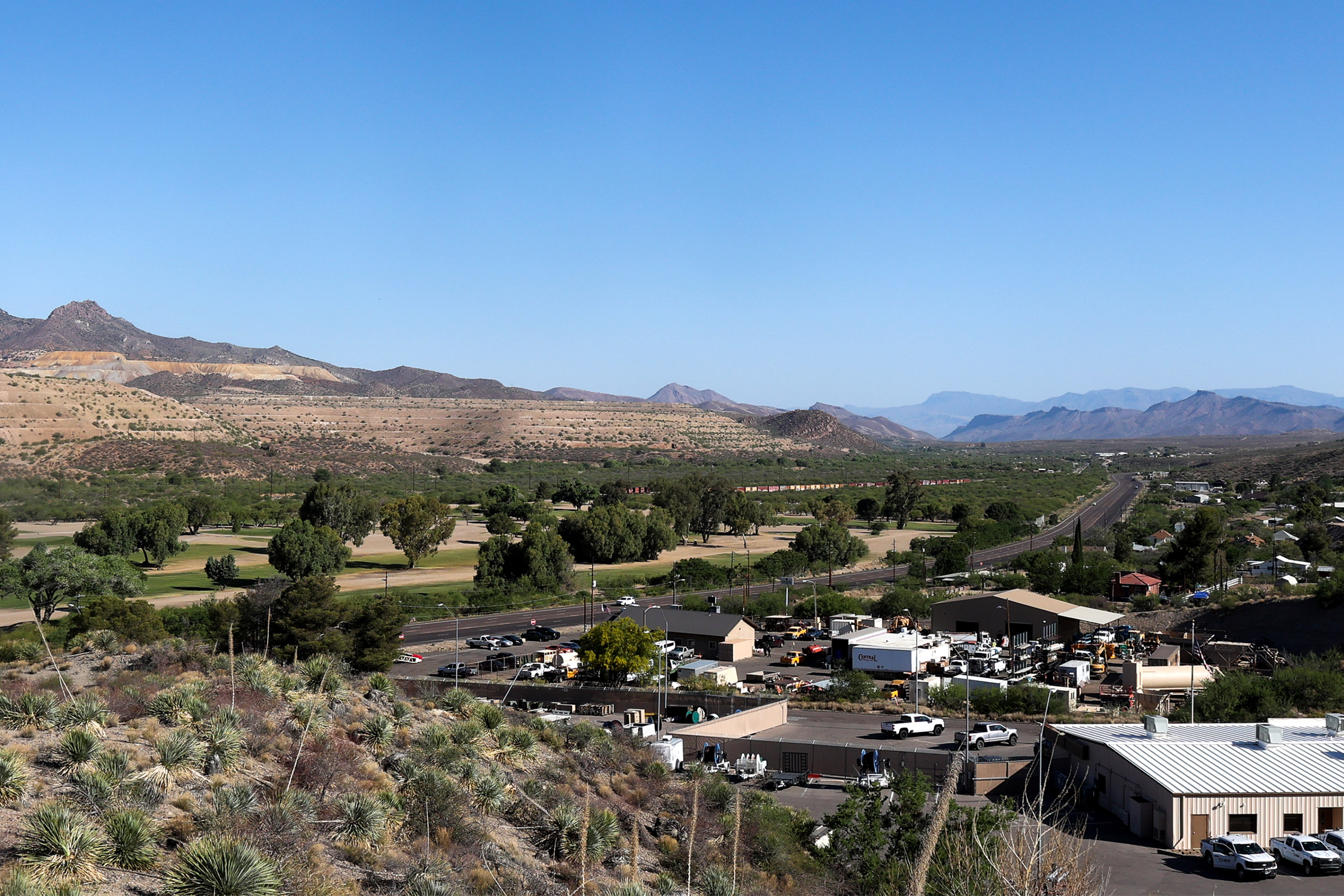 A landscape photo shows the town of Globe, Arizona, surrounded by mine tailings: raised rock formations which are a byproduct of the copper mining process.