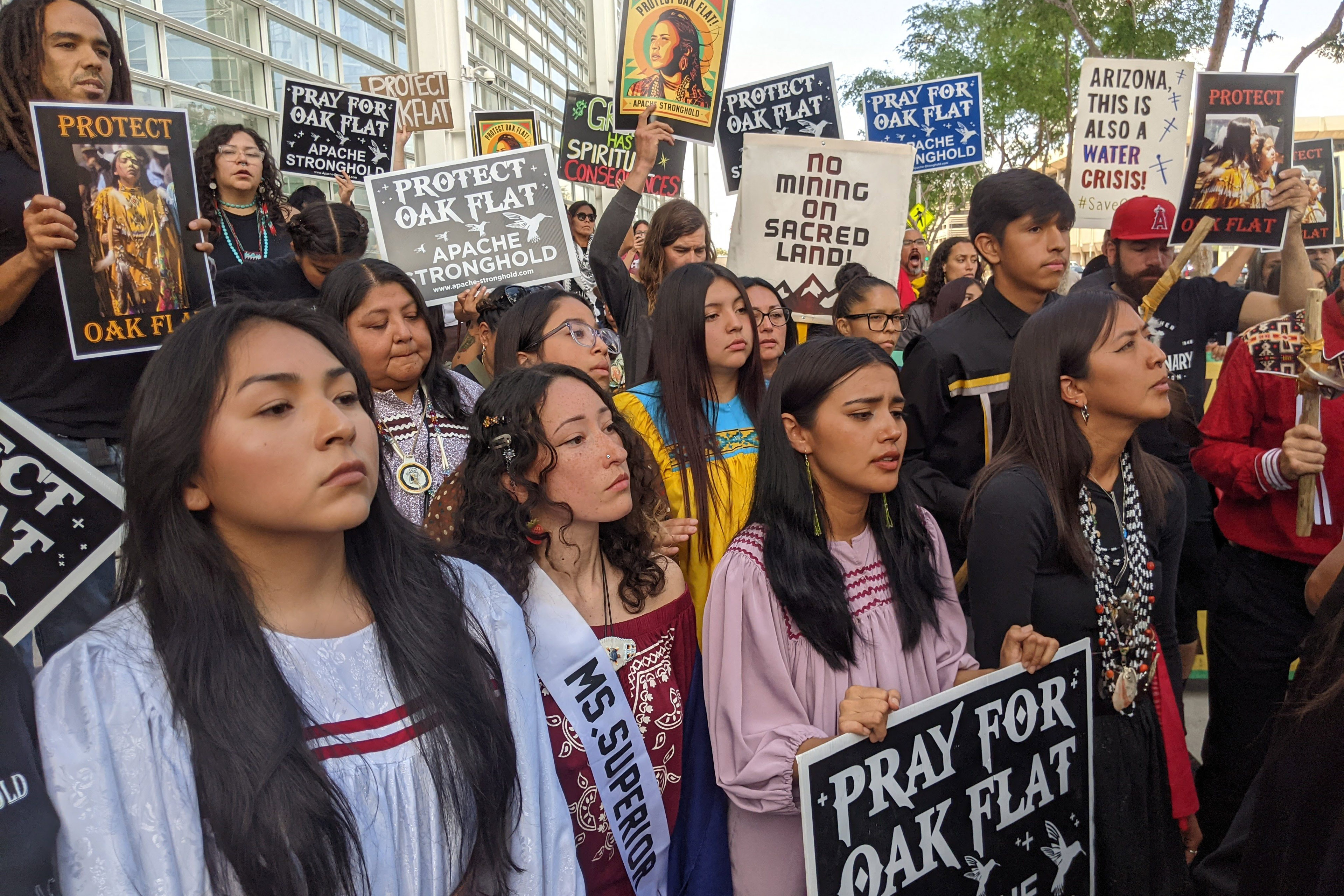 A photo of a crowd of protesters holding signs that read, "Protect Oak Flat."