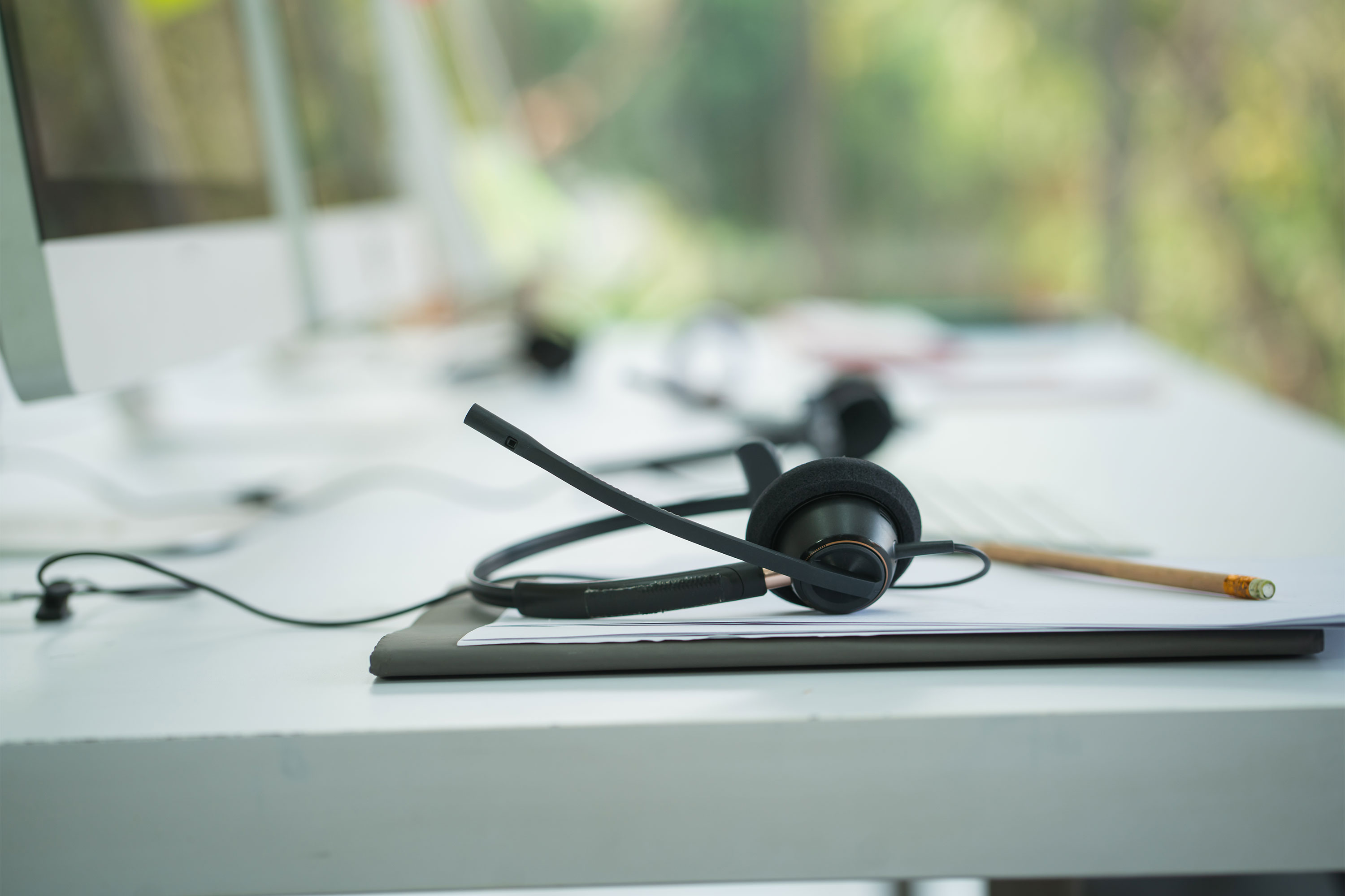 A photo of a call center employee's headset resting on a desk.