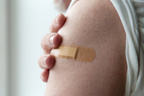 A photo of an arm bandaged after receiving a vaccine.