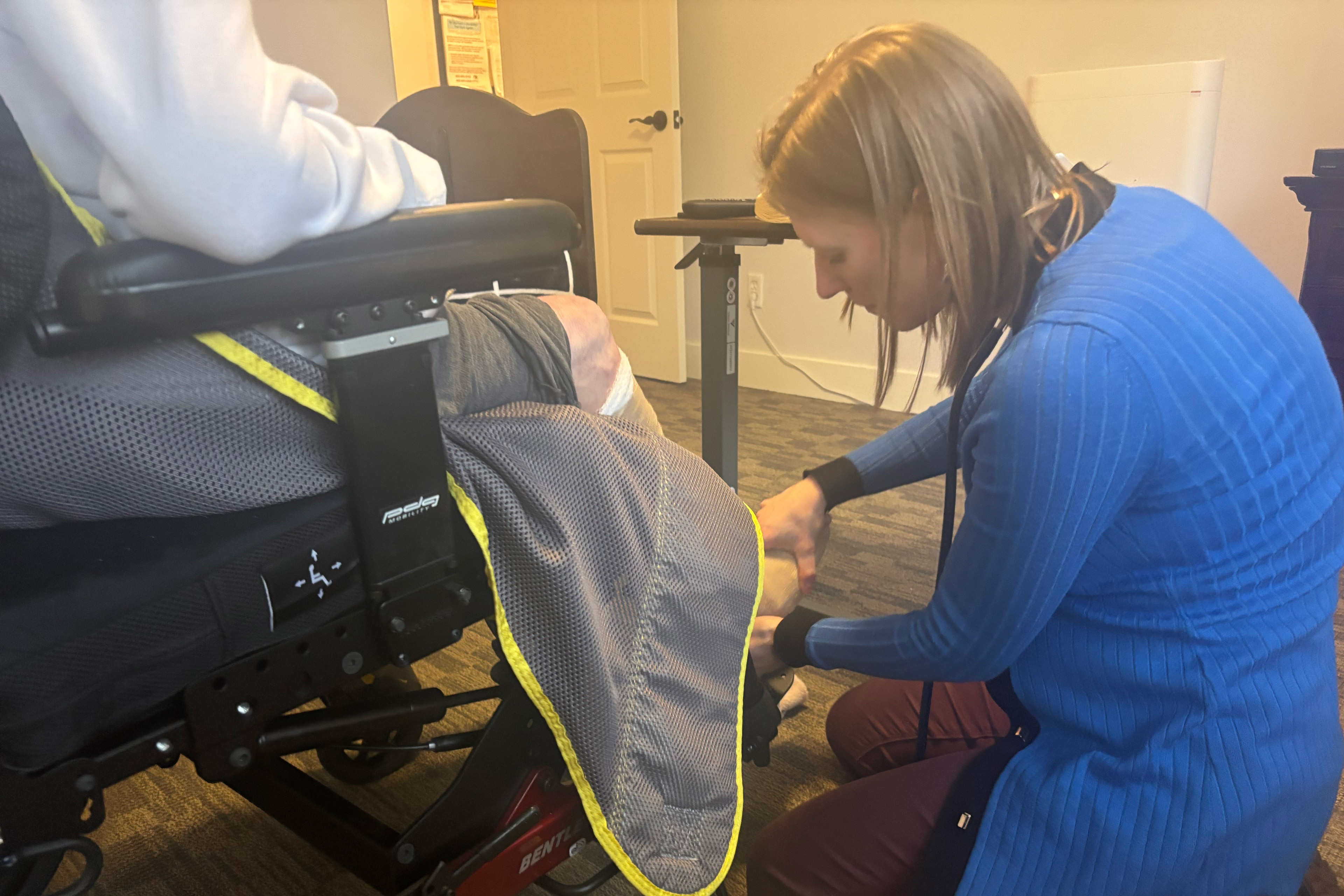A photo of Stephanie Johnson examining her patient's foot.