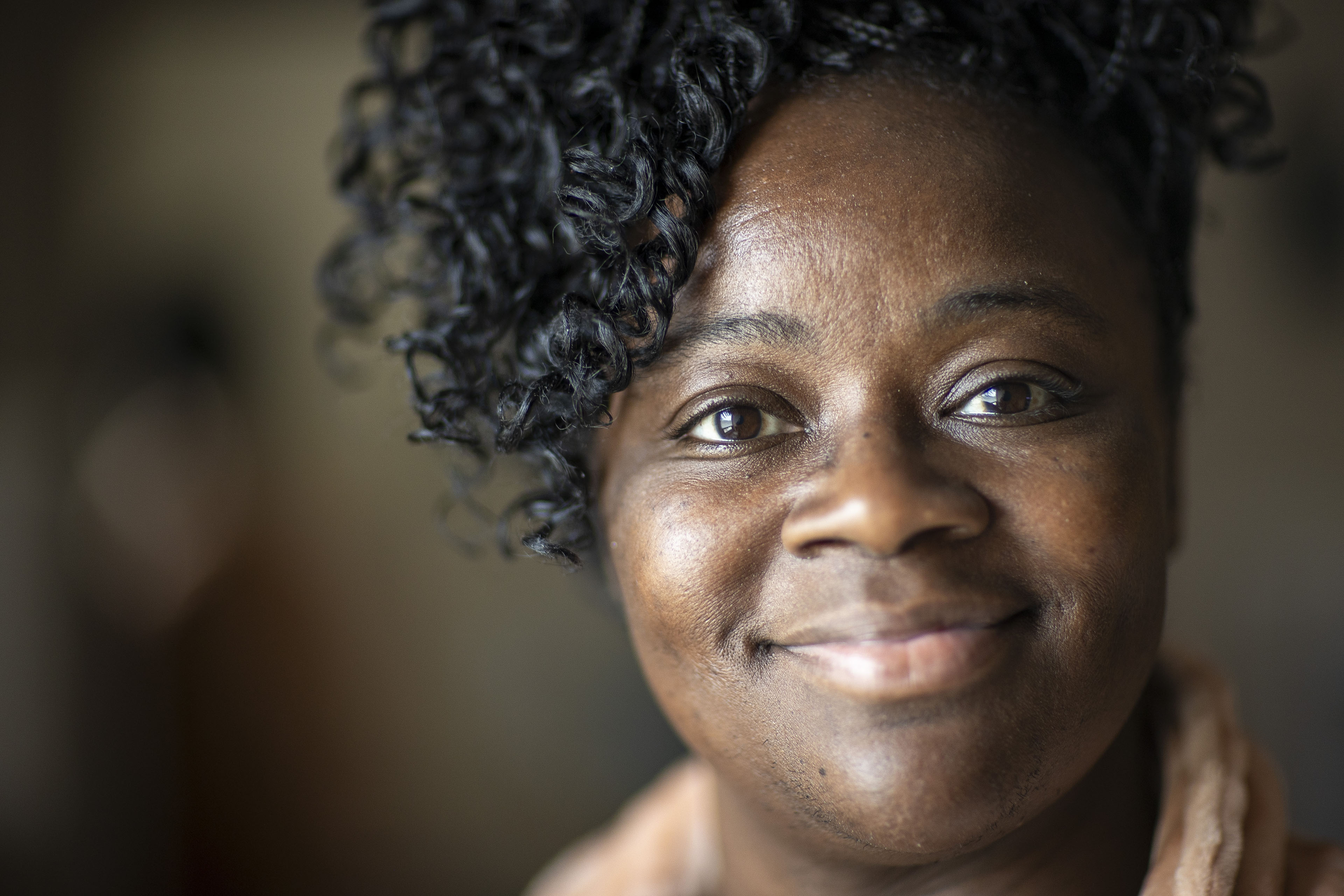 A close up a shot of a woman's face, who is smiling.