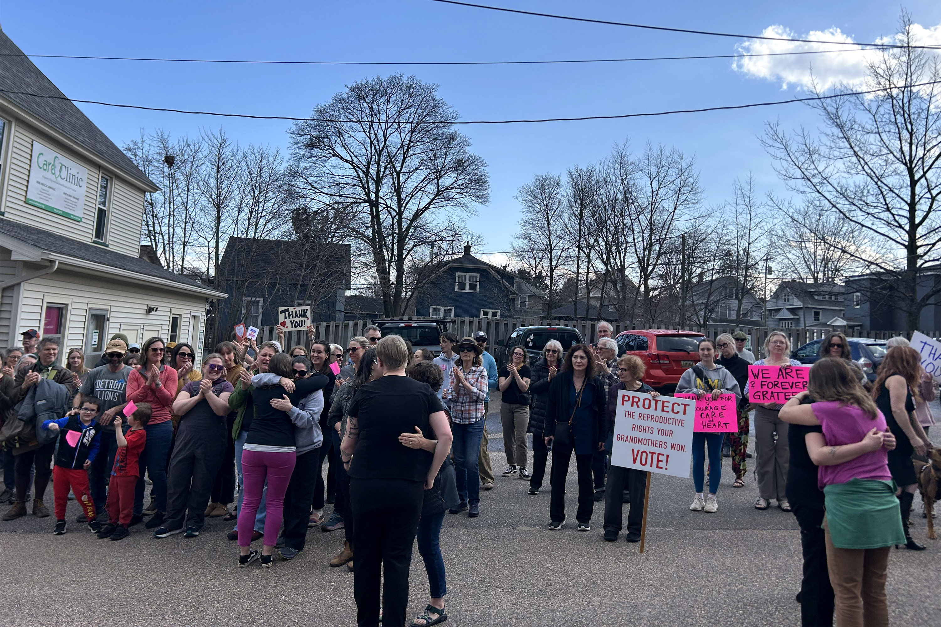 A photo of a crowd of people, some carrying signs expressing gratitude to Planned Parenthood staffers.