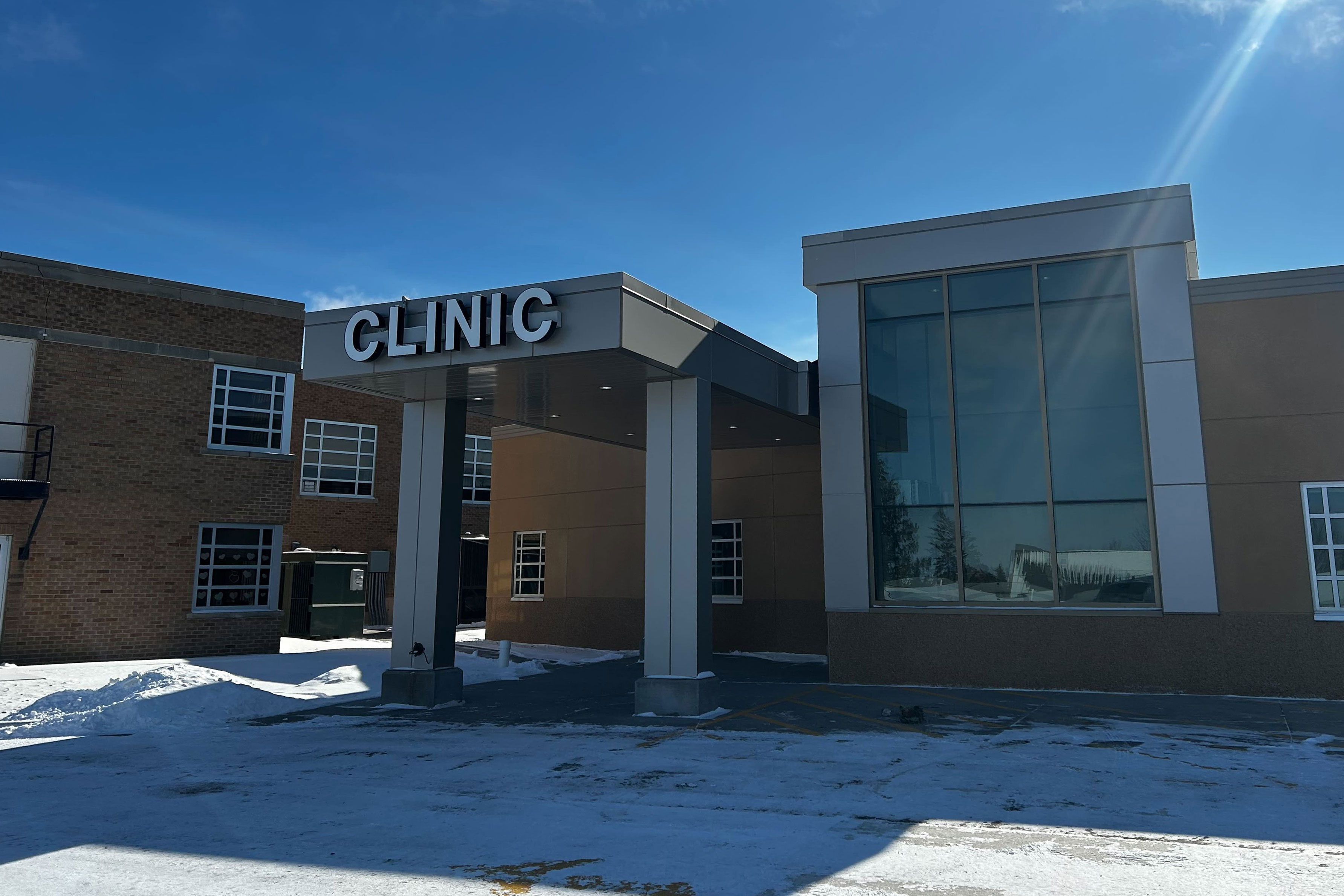 The entrance to a building with a sign reading "Clinic" above the portico.