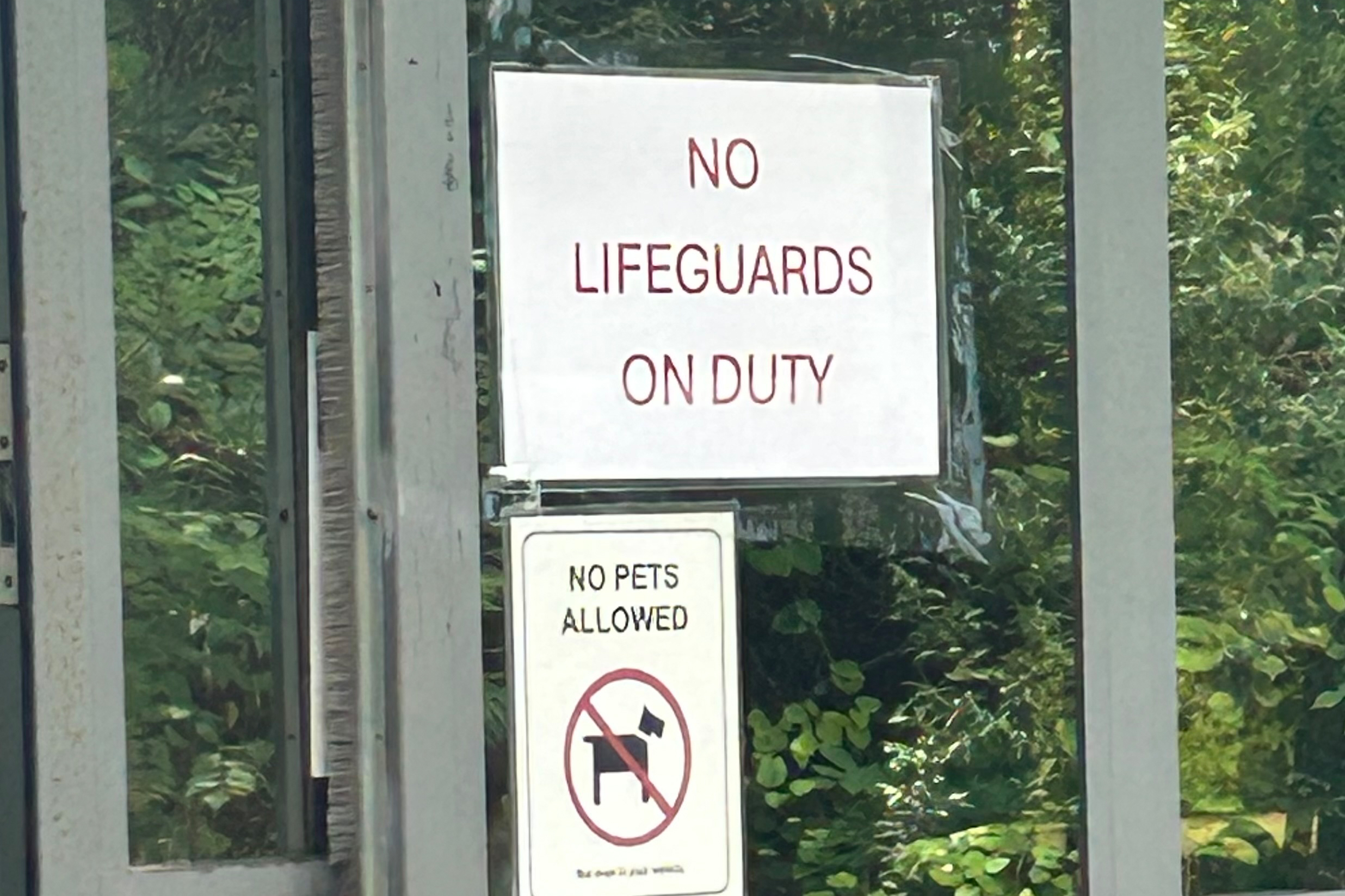 A photo of a sign on a glass pane that reads, "No lifeguards on duty."