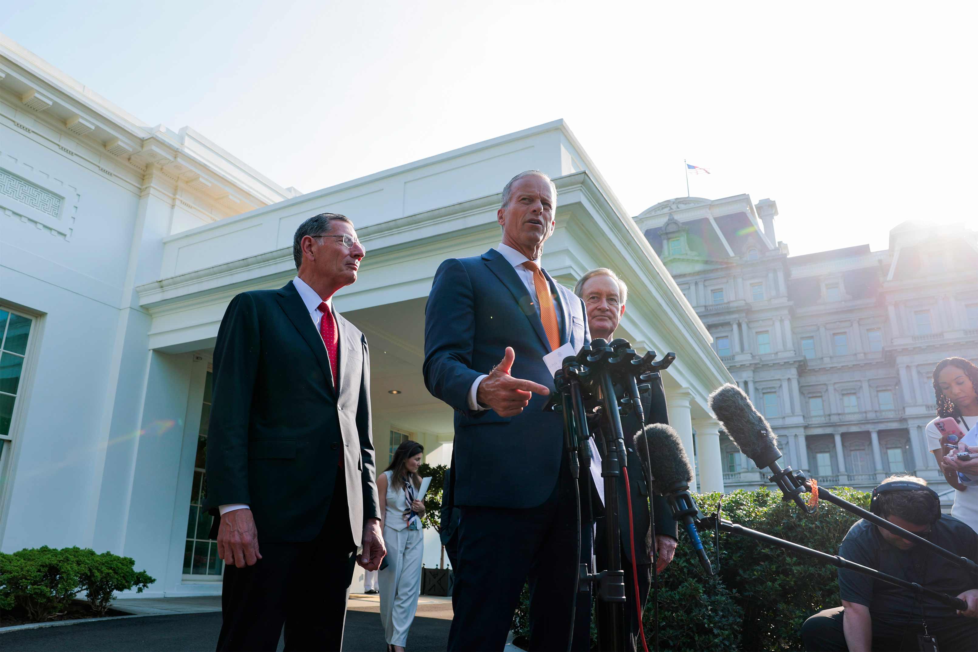 A photo of three US senators standing for a news huddle outside of the White House.
