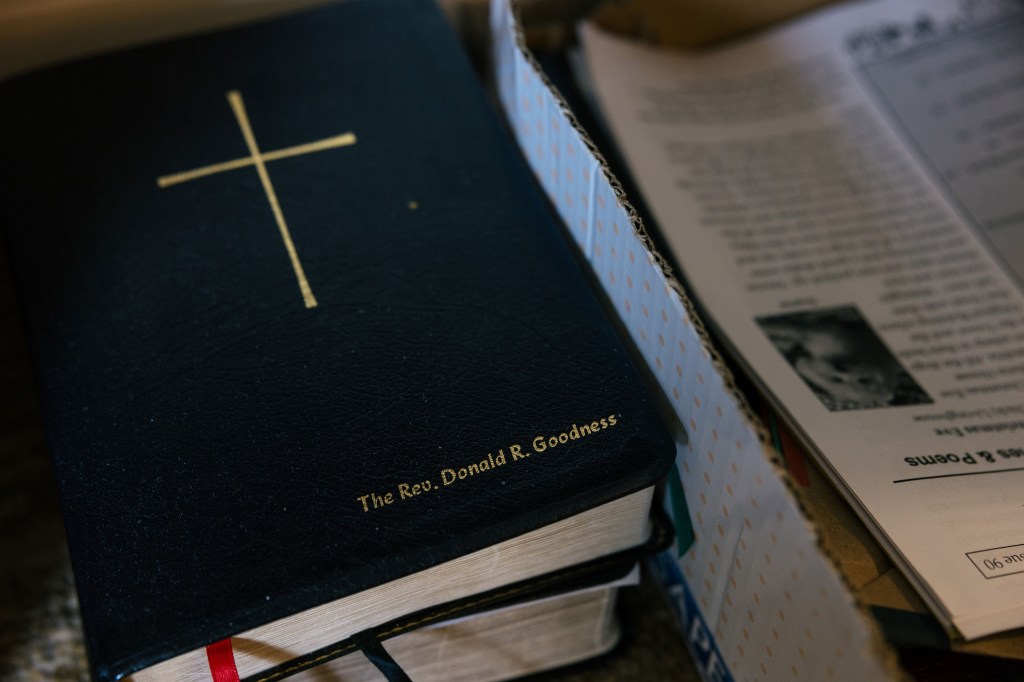 An up-close photograph of a Bible that has the name "The Rev. Donald R. Goodness" embossed on the front below a large gold cross.
