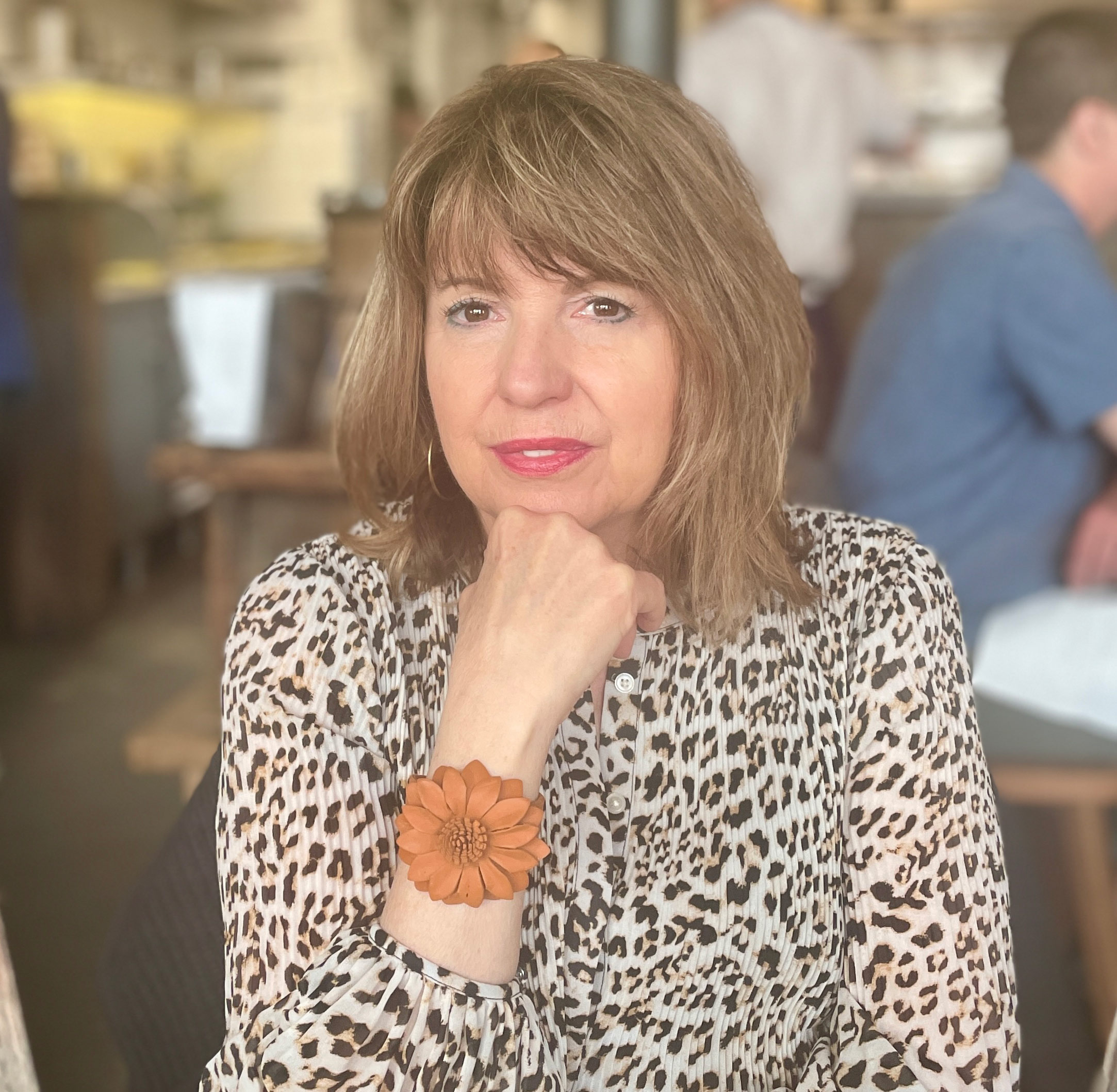 A photo of a woman sitting inside a restaurant.